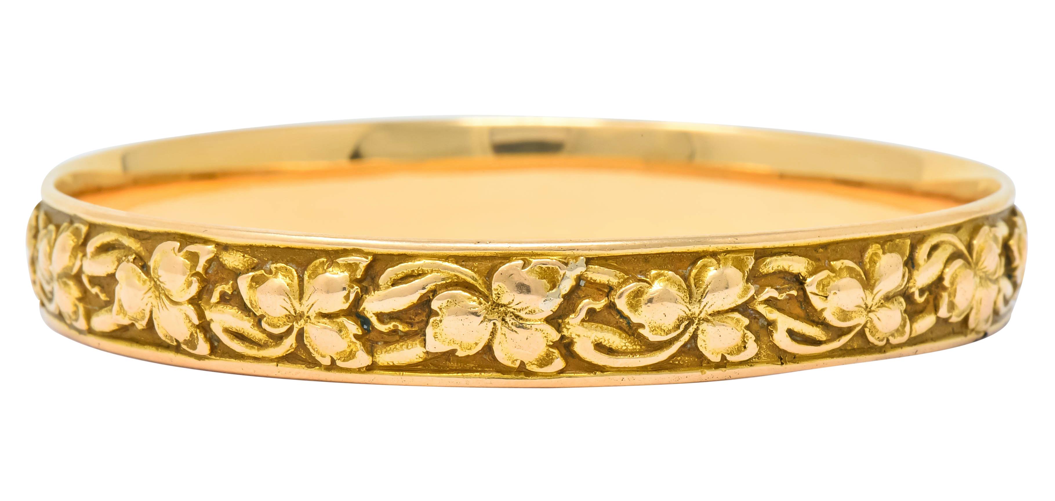 Bangle style bracelet with two polished edges framing a recessed matte gold channel

Channel decorated with highly rendered, polished, crawling ivy motif

Fully signed Shreve & Co. and stamped 14k for 14 karat gold

Inner circumference: 7 3/4