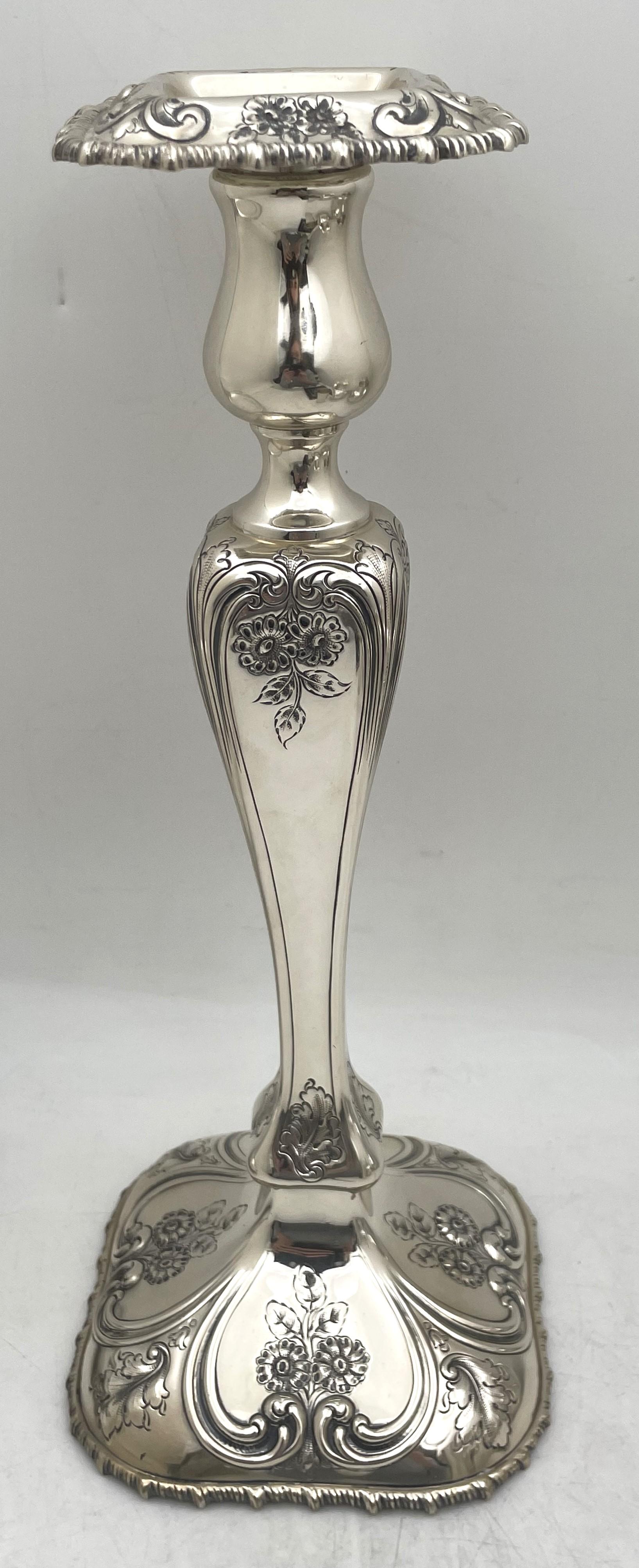 Shreve & Co. pair of sterling silver candlesticks in Art Nouveau style from the early 20th century, beautifully adorned with floral and curvilinear motifs. They measure 12 3/4'' in height by 5 1/4'' in depth, are weighted (gross weight is 55 troy