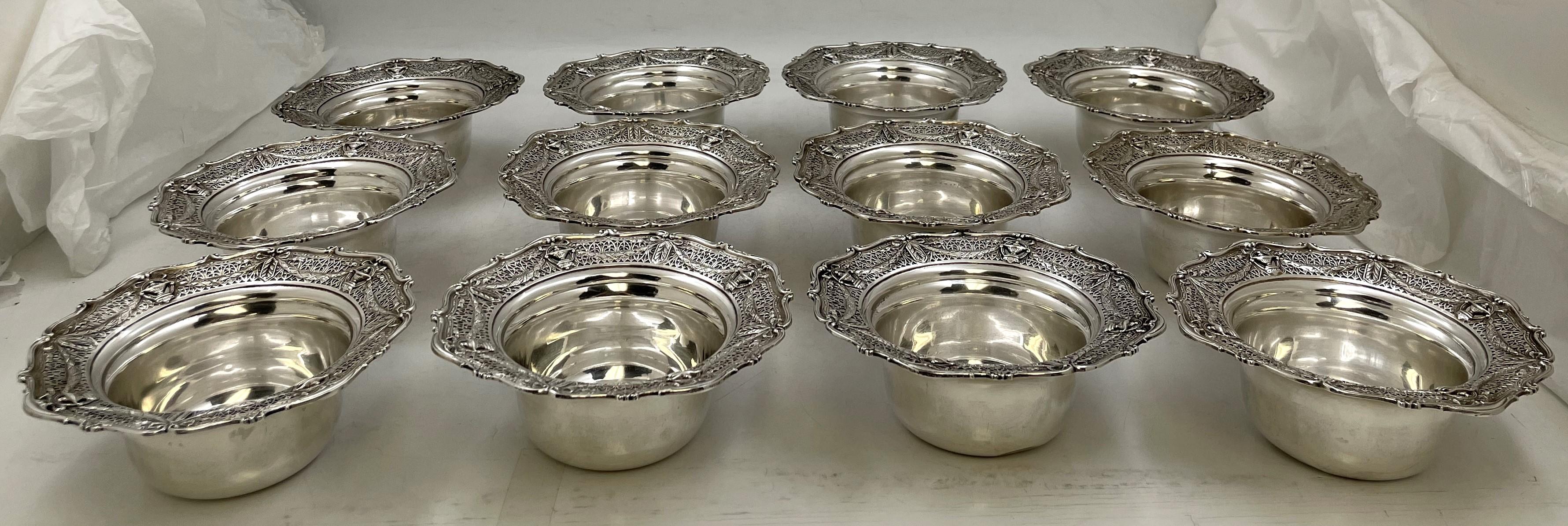 Ensemble de 12 coupes à dessert en argent sterling de la marque Adams, dont les bords sont ornés de couronnes, de rubans et d'urnes dans un motif exquis et ajouré. Ils mesurent 5 7/8'' de diamètre (4'' sans le bord) par 2 1/4'' de hauteur, pèsent 50