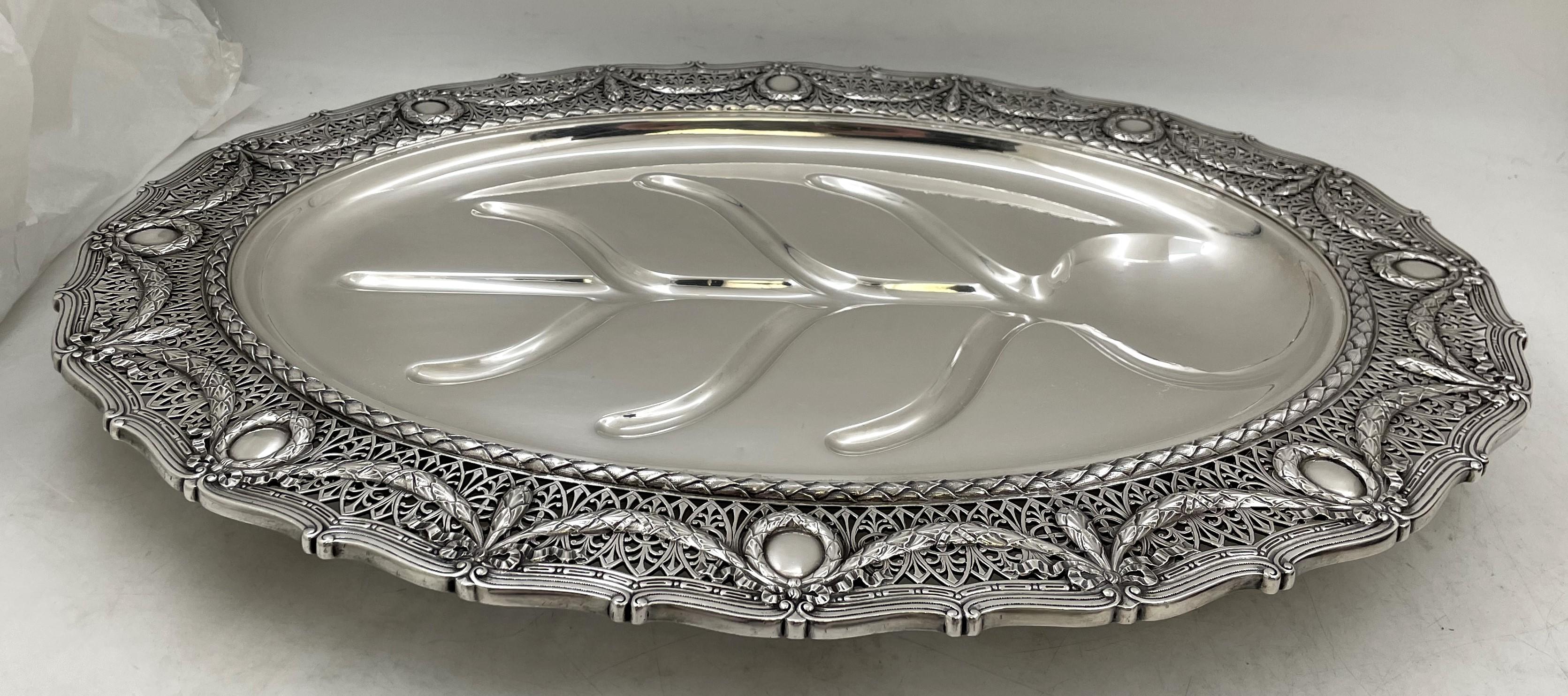 Plato para carne con pozo y árbol de plata de ley de Shreve & Co., de pie sobre 4 patas, en diseño Luis XVI, el borde adornado con motivos calados y coronas, de principios del siglo XX. Mide 21'' de longitud por 15 1/2'' de profundidad y 1 2/3'' de