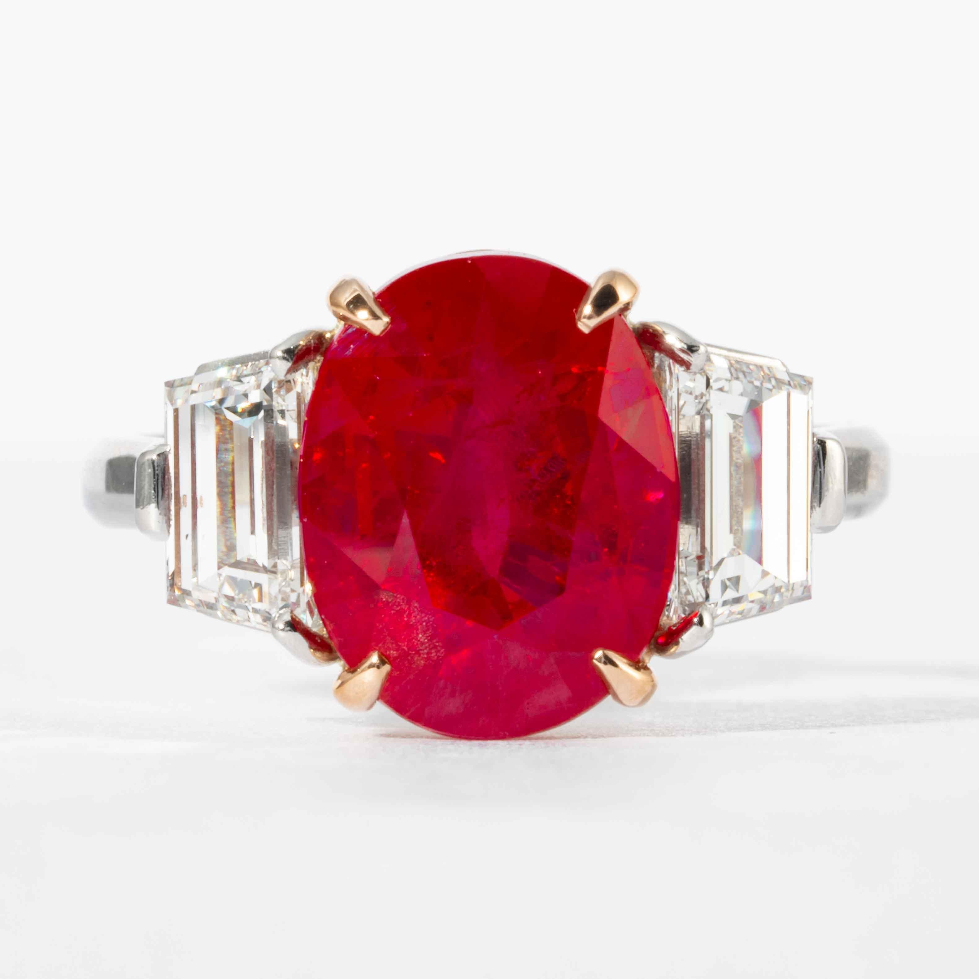 This ruby and diamond 3-stone ring is offered by Shreve, Crump & Low.  Platinum custom made 3-stone ring consisting of one oval cut Burma ruby weighing 5.45 carats with AGL certificate No. CS44053, the center stone is flanked by 2 step cut trapezoid