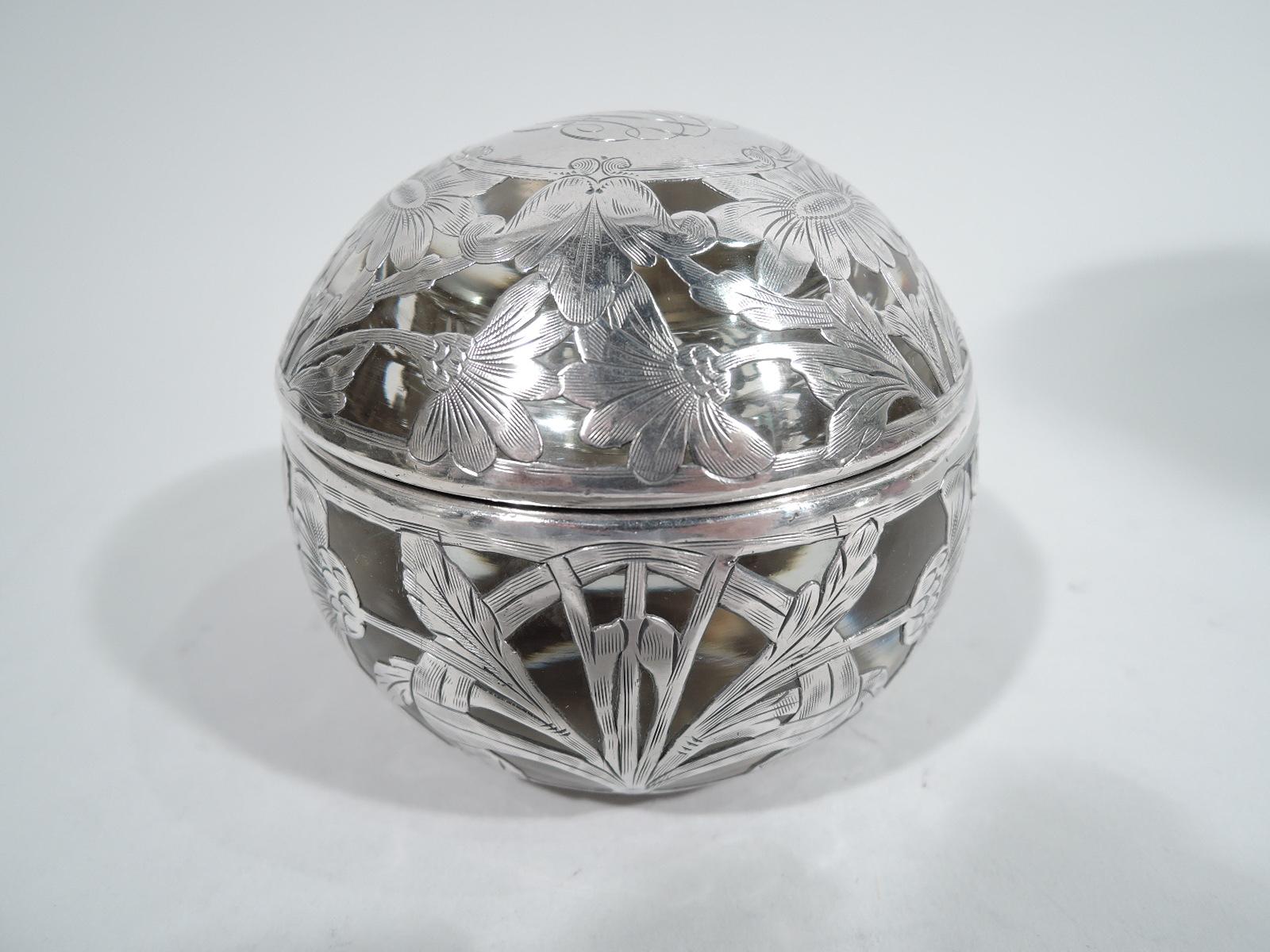 Turn-of-the-century Art Nouveau glass inkwell with engraved silver overlay. Retailed by Shreve, Crump & Low in Boston. Globular. Body has flat top and short inset neck. Cover interior has corresponding well. Flower overlay with tendrils forming