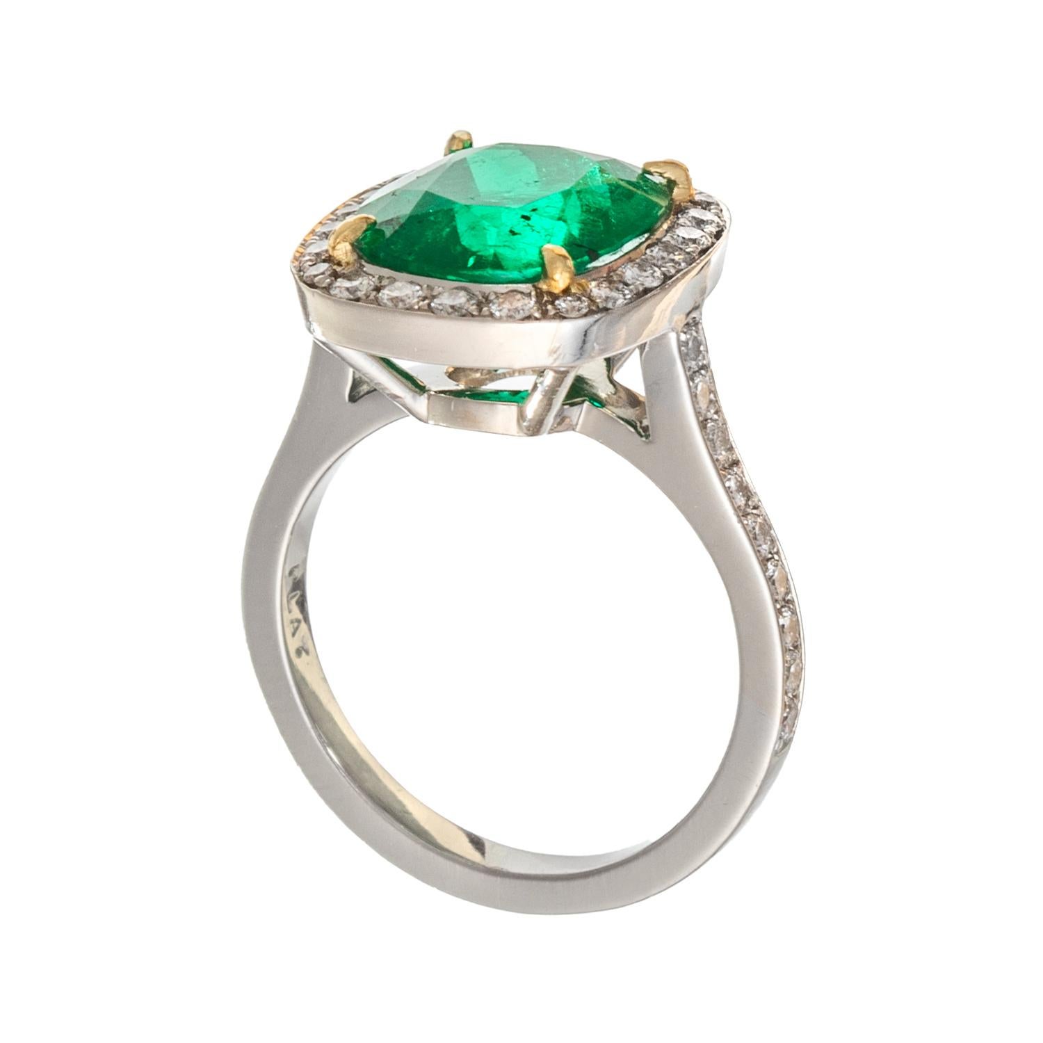 Fine handmade platinum ring, centering a cushion-shaped faceted, natural Colombian emerald, framed by round brilliant-cut diamonds with partway bead-set round brilliant-cut diamond shoulders.  Emerald weighing 3.94 carats and measuring 11.33 x 10.03
