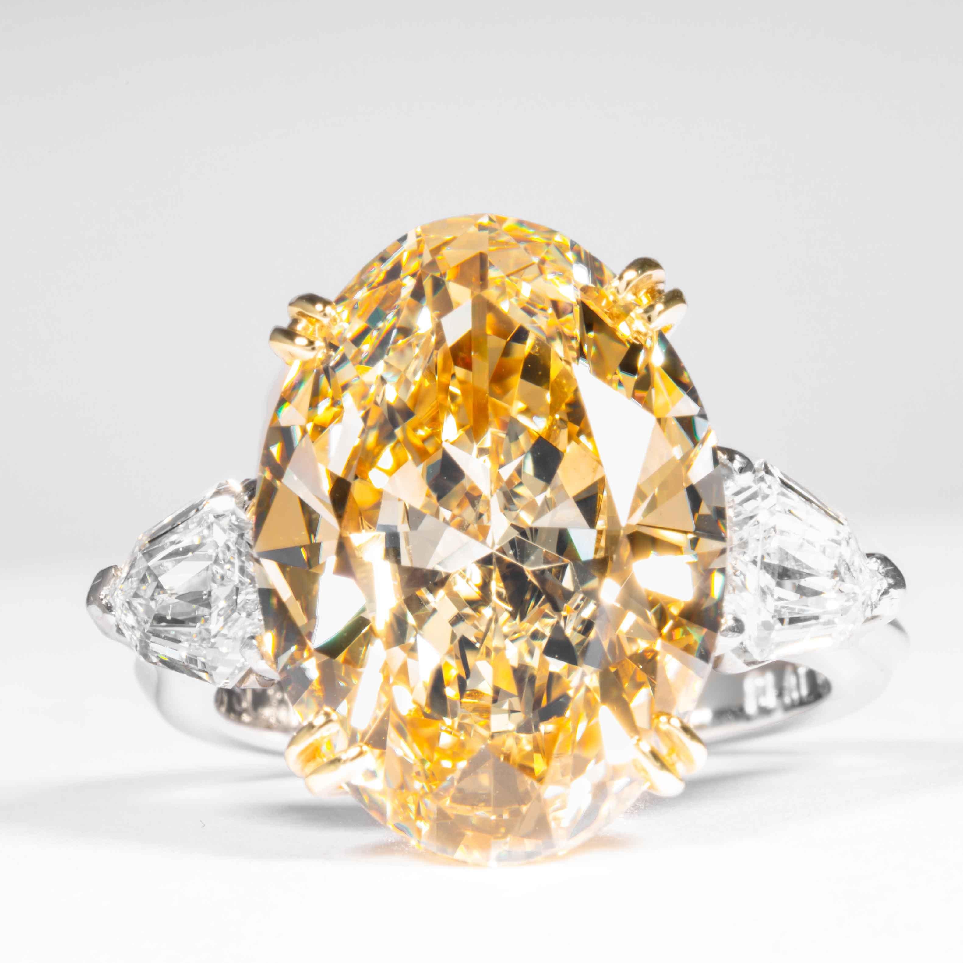 This fancy yellow oval cut diamond is offered by Shreve, Crump & Low.  This fancy yellow oval diamond is custom set in a handcrafted Shreve, Crump & Low platinum and 18 karat yellow gold 3 stone ring consisting of 1 oval cut yellow diamond weighing