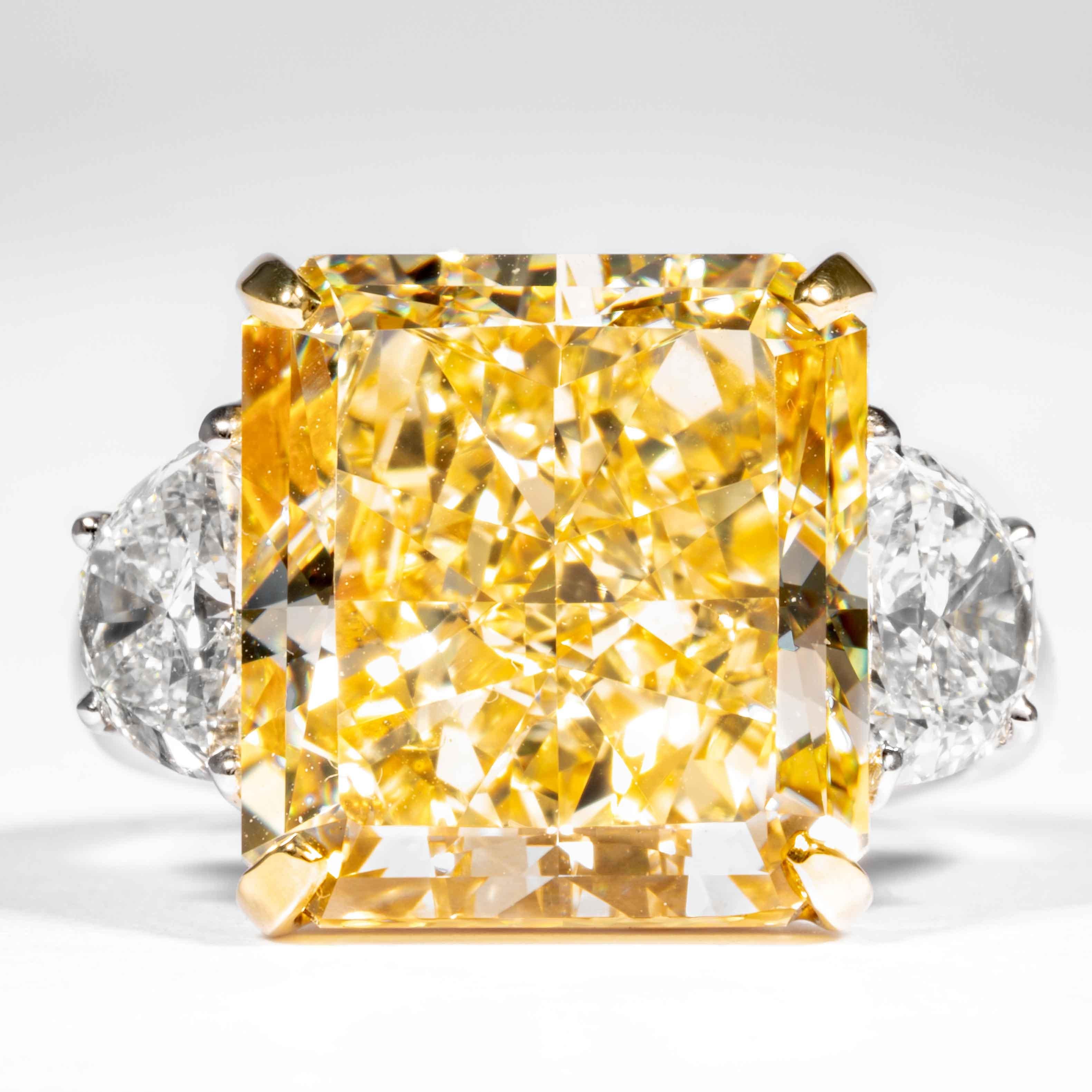 Dieser fancy-gelbe strahlende Diamant wird von Shreve, Crump & Low angeboten.  Der Diamant im Radiant-Schliff ist in einem handgefertigten Ring aus Platin und 18 Karat Gelbgold von Shreve, Crump & Low mit drei Steinen gefasst. Der Ring besteht aus
