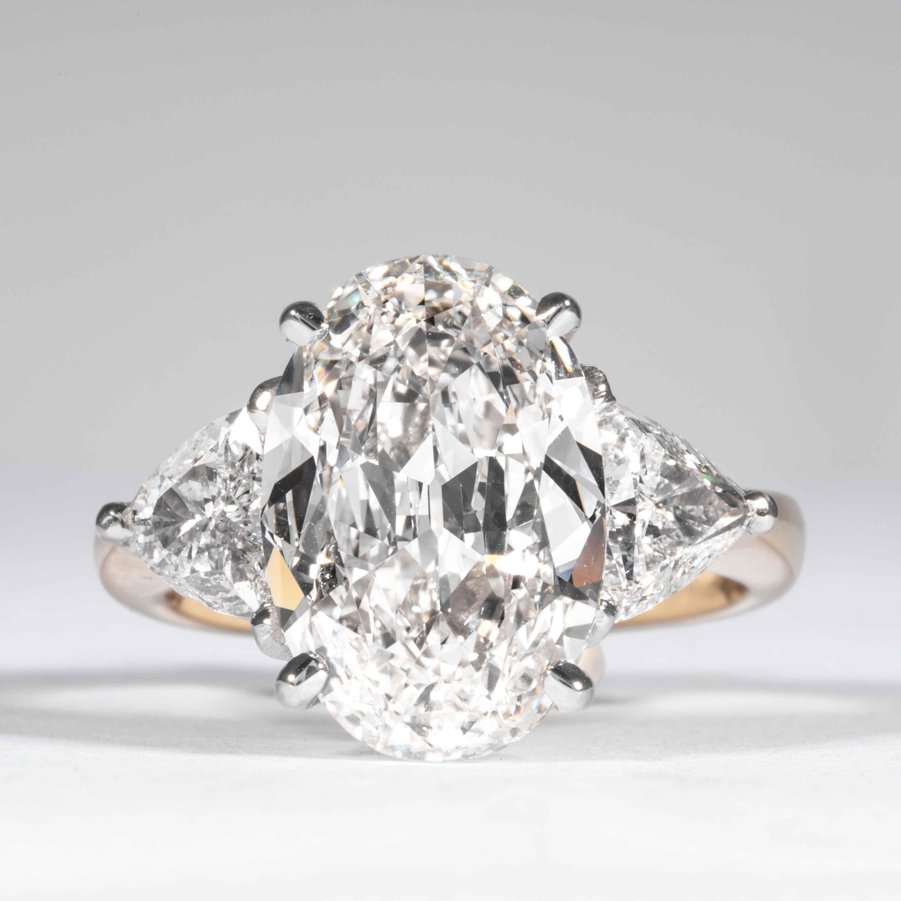 Questo classico anello con diamante a taglio ovale è offerto da Shreve, Crump & Low. Questo diamante di taglio ovale da 5,03 carati certificato GIA H VS1 e dalle dimensioni di 14,15 x 9,62 x 4,83 mm è incastonato su misura in un anello a tre pietre