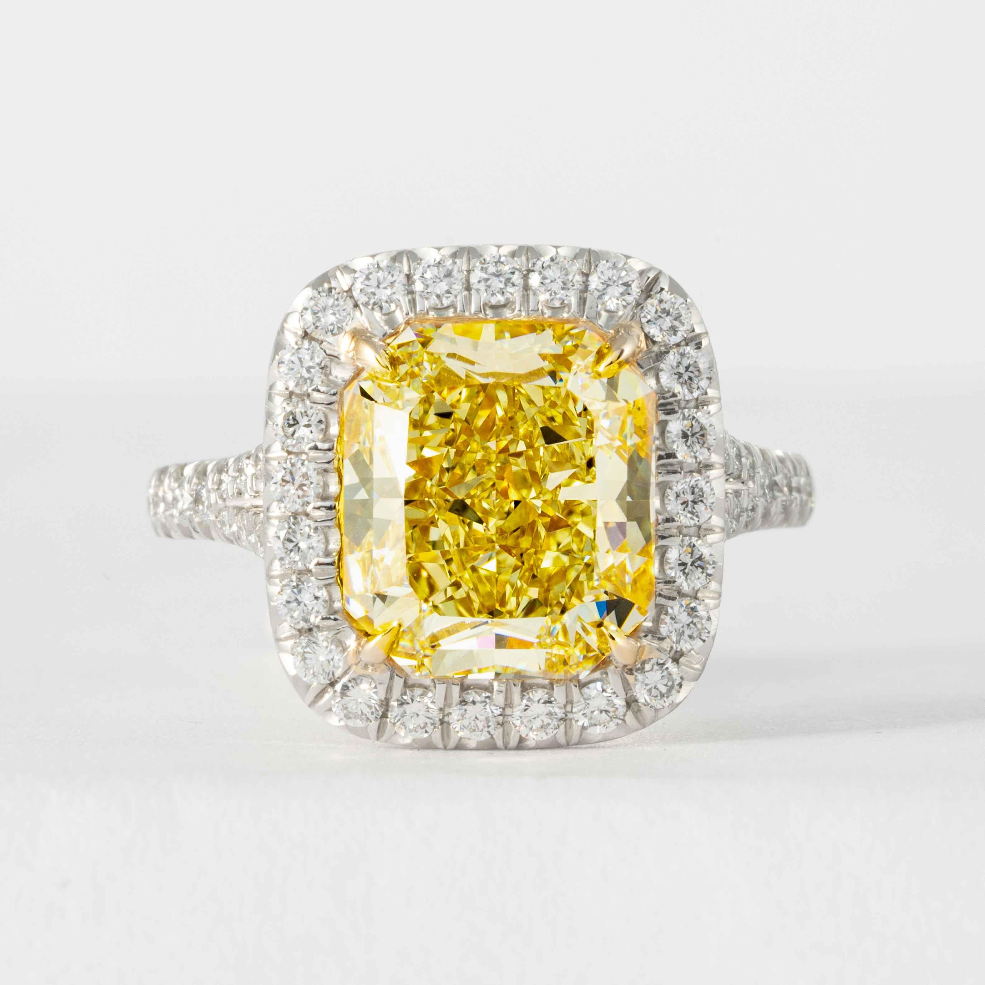 This fancy intense yellow radiant cut diamond is offered by Shreve, Crump & Low. This fancy yellow Radiant cut diamond is custom set in a handcrafted Shreve, Crump & Low platinum and 18 karat yellow gold halo ring consisting of 1 radiant cut yellow