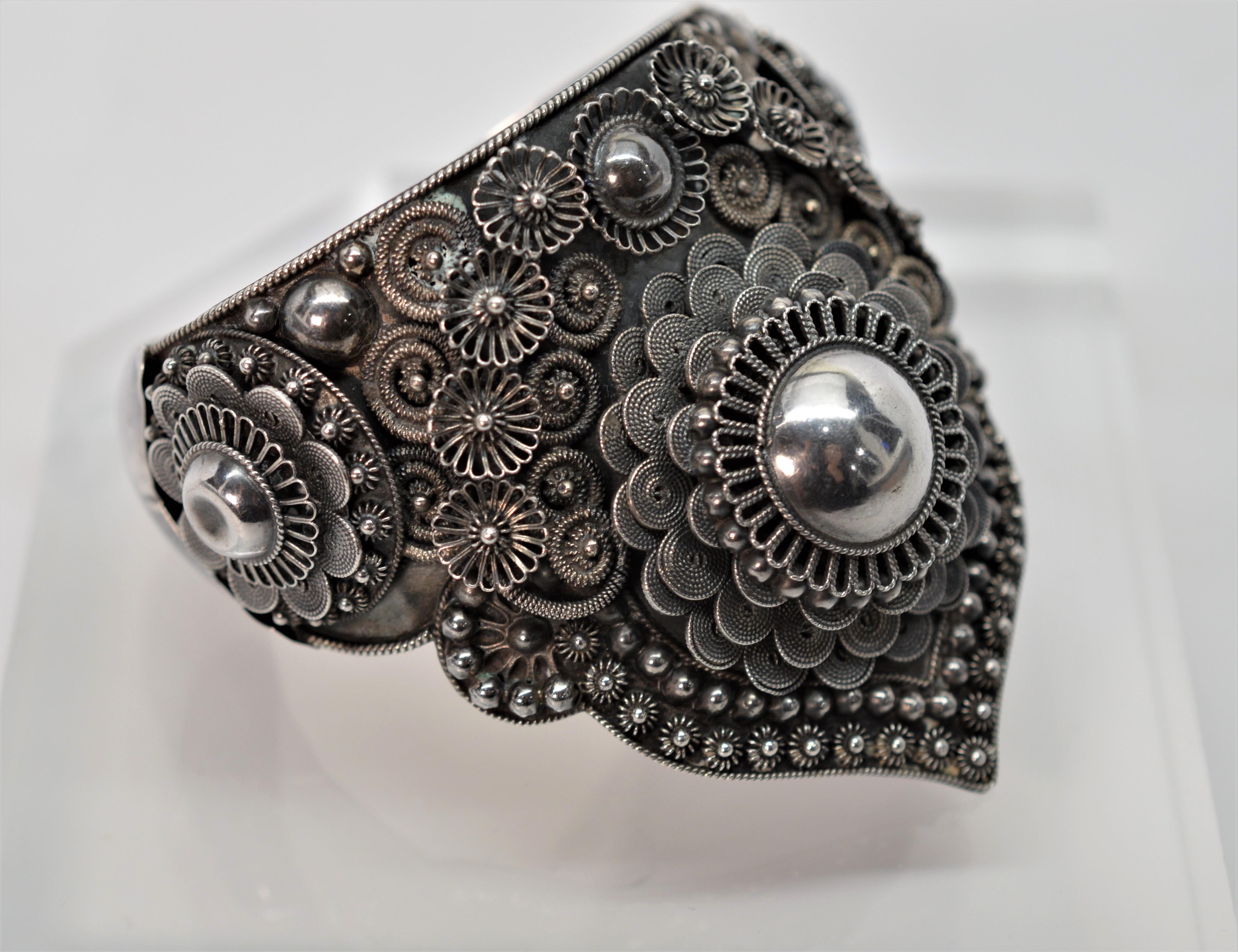 A spectacular three dimensional work of art in silver with lace like flowers, beads, balls and spiral rope designs. The bold handkerchief shape is fully adorned with fabulous artisan silver appliques. Measures approximately 2-1/2 inches to the