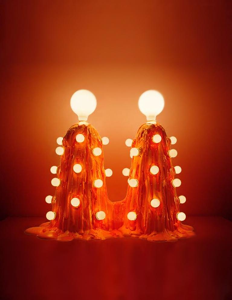 This piece is molded in a paper composite, then has expandable foam poured over the surface. Multiples pours create the puddling effect at the bottom of the piece. Two large LED bulbs are on top, along with 7.5w incandescent bulbs throughout the
