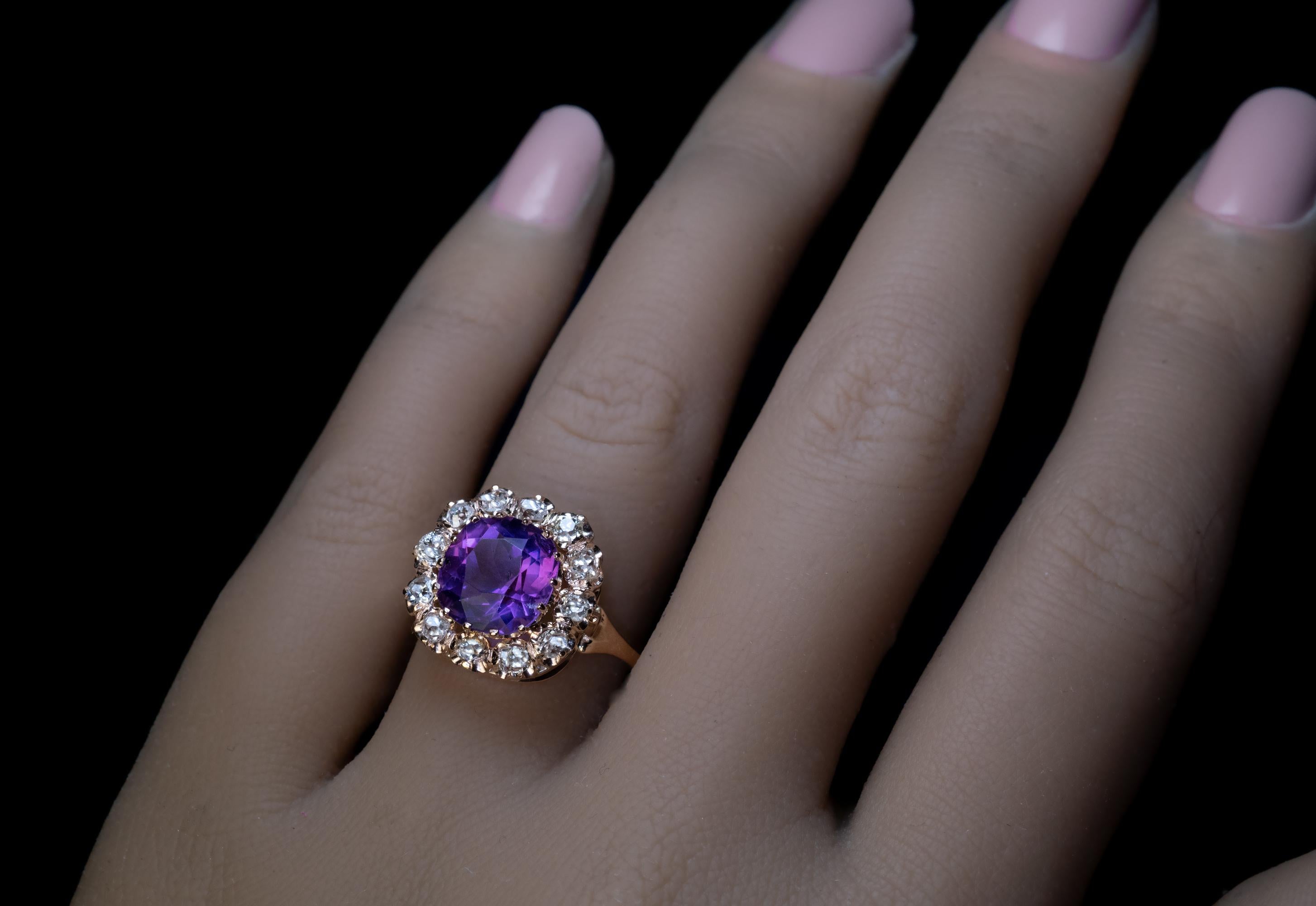 Russia, circa 1880s.
This antique 14K gold cluster ring features an old cushion cut Siberian amethyst of an excellent pinkish bluish purple color. The stone is full of life and very sparkly. It is framed by chunky old mine cut diamonds.
The amethyst