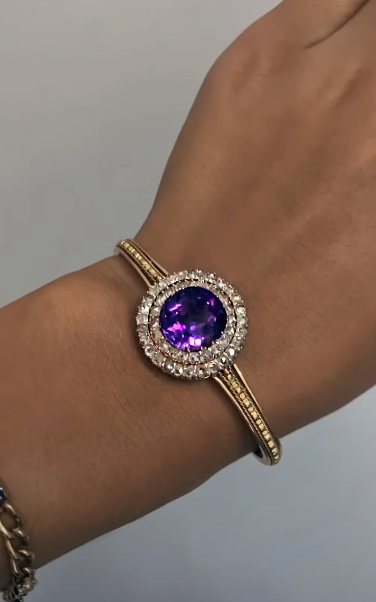 Made in Saint Petersburg, Russia, circa 1890.
The 14K gold bangle bracelet is centered with an excellent Siberian amethyst of a velvety pinkish royal purple color. The amethyst is surrounded by two rows of sparkling old rose cut diamonds. The