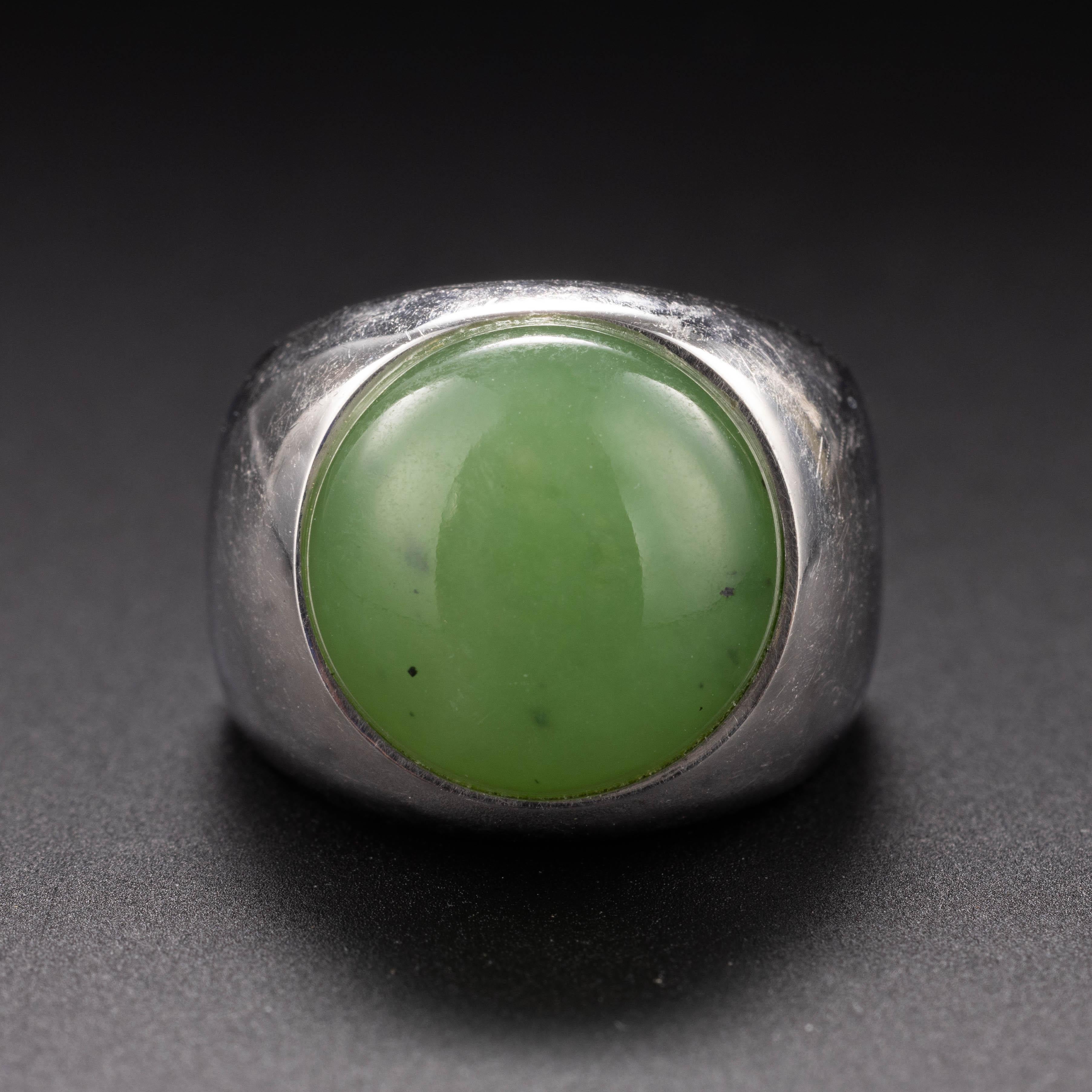 Hand-crafted in gleaming white 18K gold, this sleek, dense ring features a round cabochon of something quite special: natural, untreated Siberian jade. The round cabochon is highly translucent and the most vivid apple green. 

Bezel-set within a