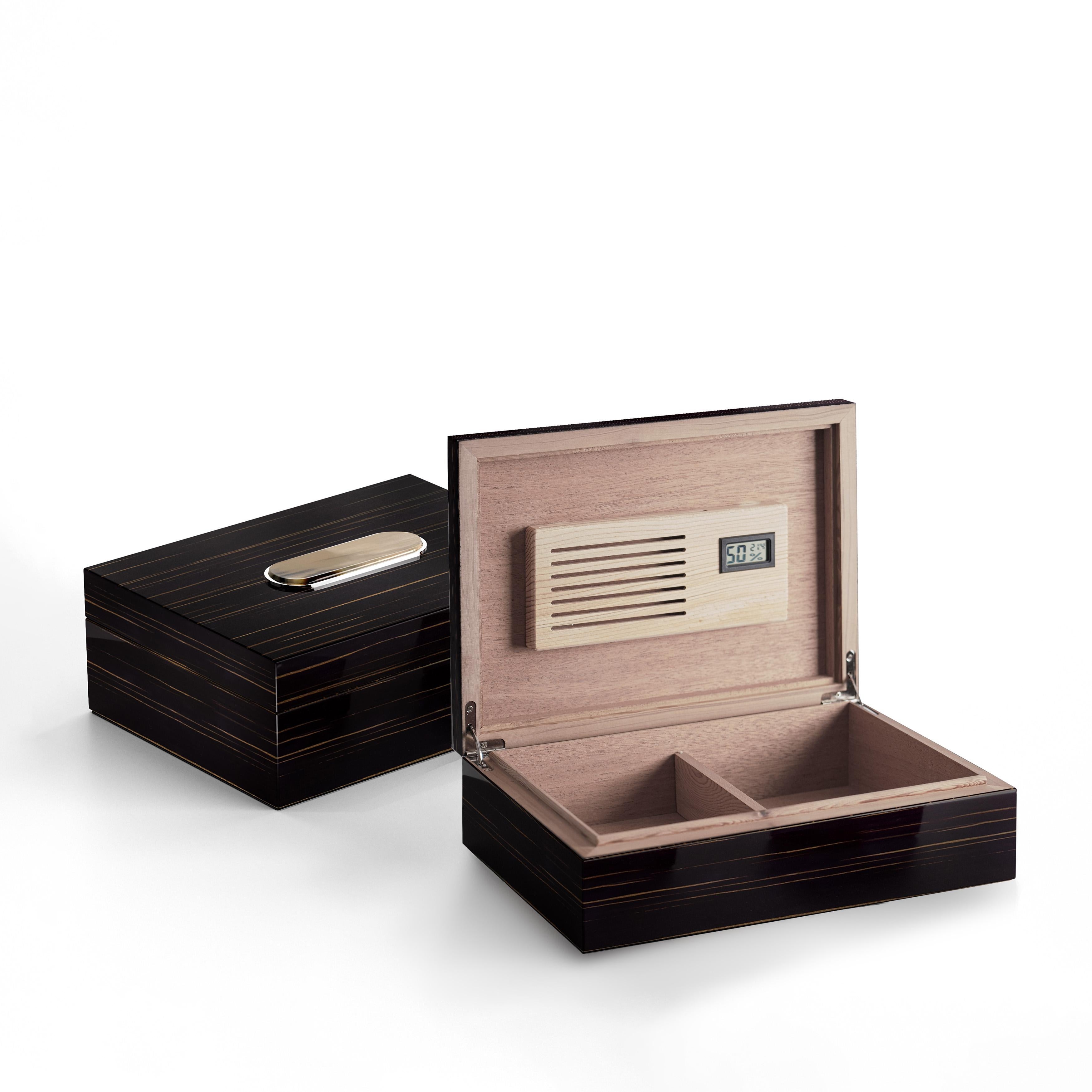Tailored for discerning smoking enthusiasts, the Sibilla cigar humidor blends exquisite materials with sophisticated design. Crafted with the utmost care, the humidor features an exterior structure in glossy ebony embellished by a decoration in