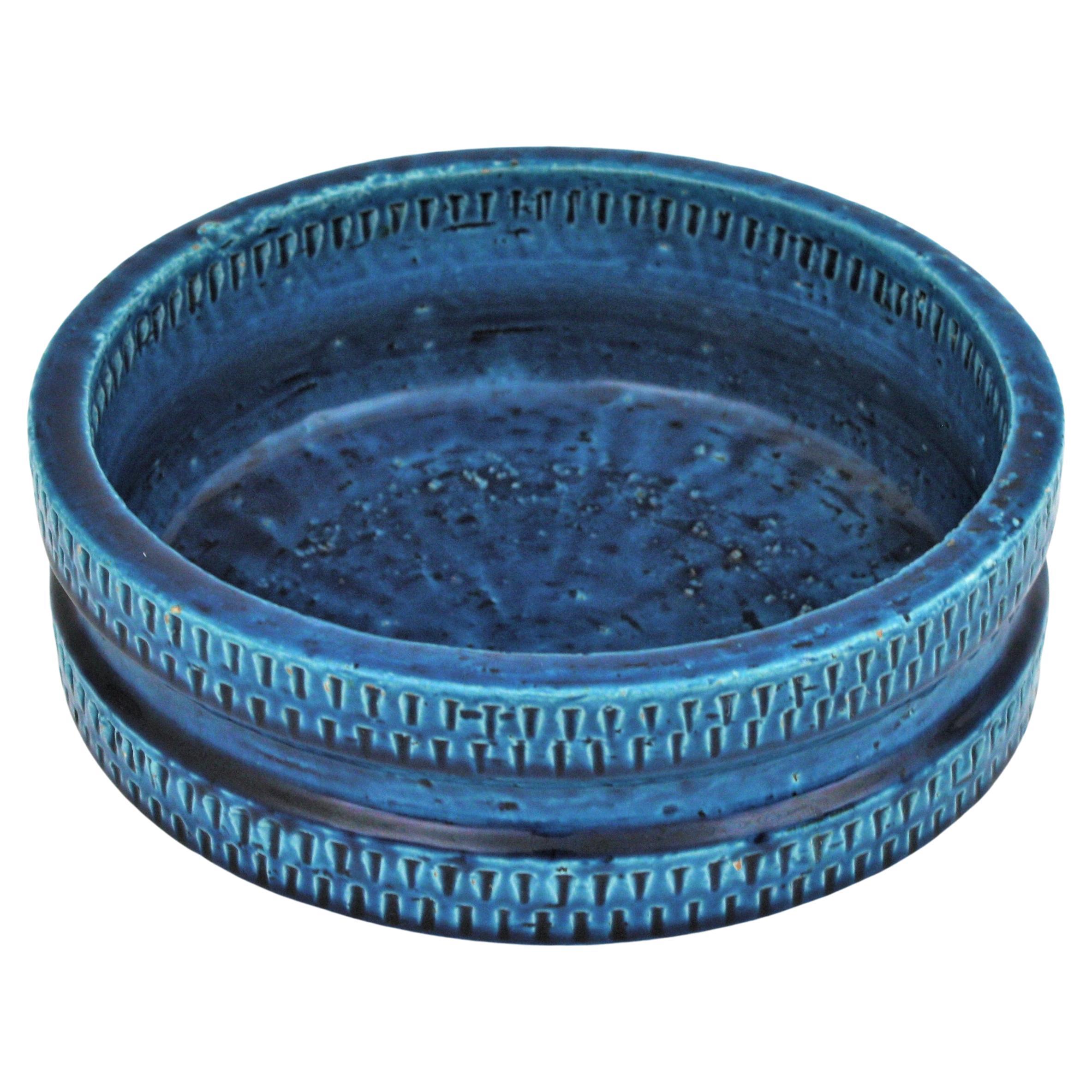 Large scale Mid-Century Modern blue glazed ceramic (Rimini Blu) round bowl /centerpiece, manufactured by S.I.C Ceramiche Italy, 1950-1960s.
It has reminiscences in those designs from Aldo Londi and Bitossi. 
Handcrafted in Italy with hand carved