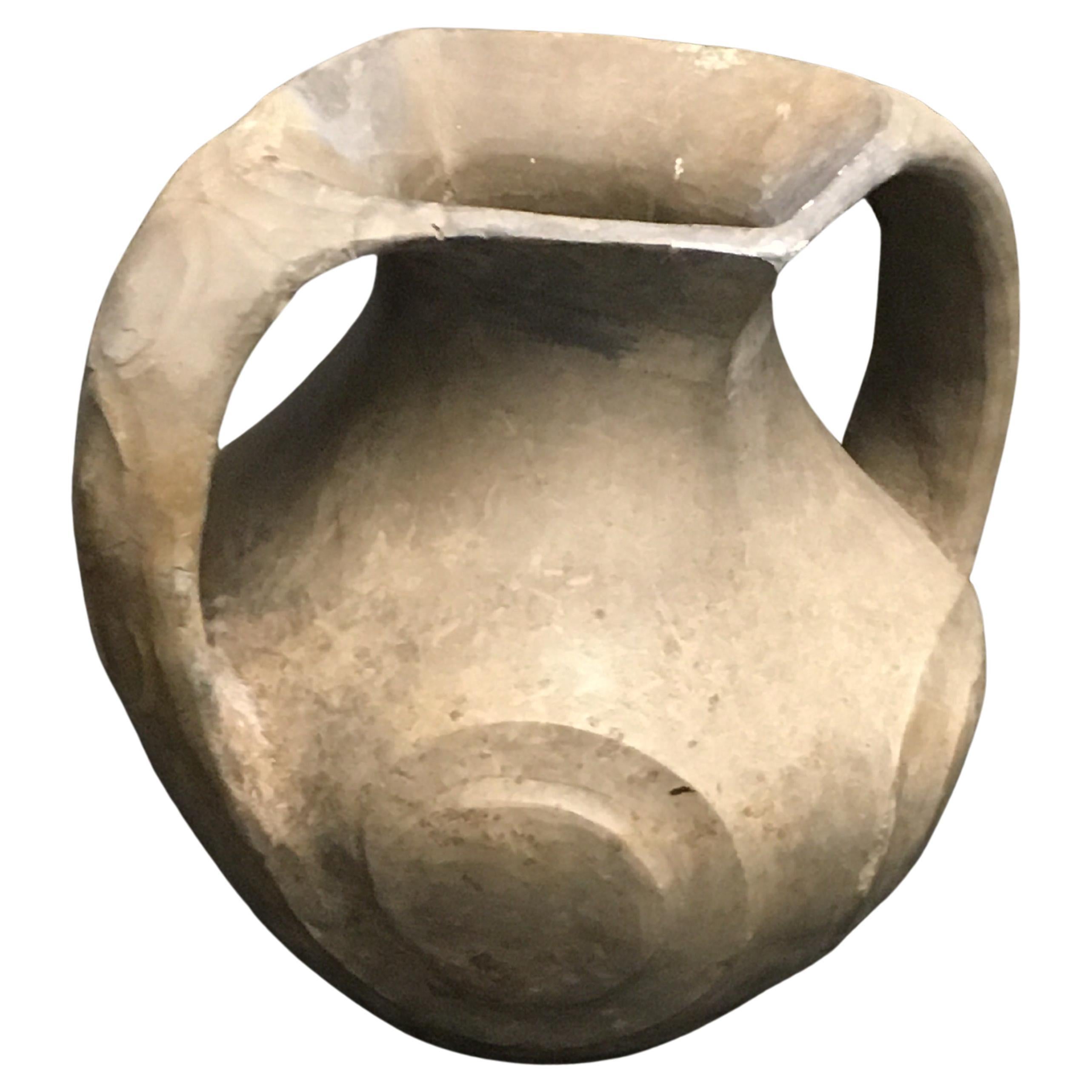 Sichuan Burnished Black Han Dynasty Pottery Amphora Vase

Of pear form with a vertically incised band around the neck beneath a lozenge-shaped opening at the mouth, the two loop handles resolving into four raised scrolls on the body supported on a