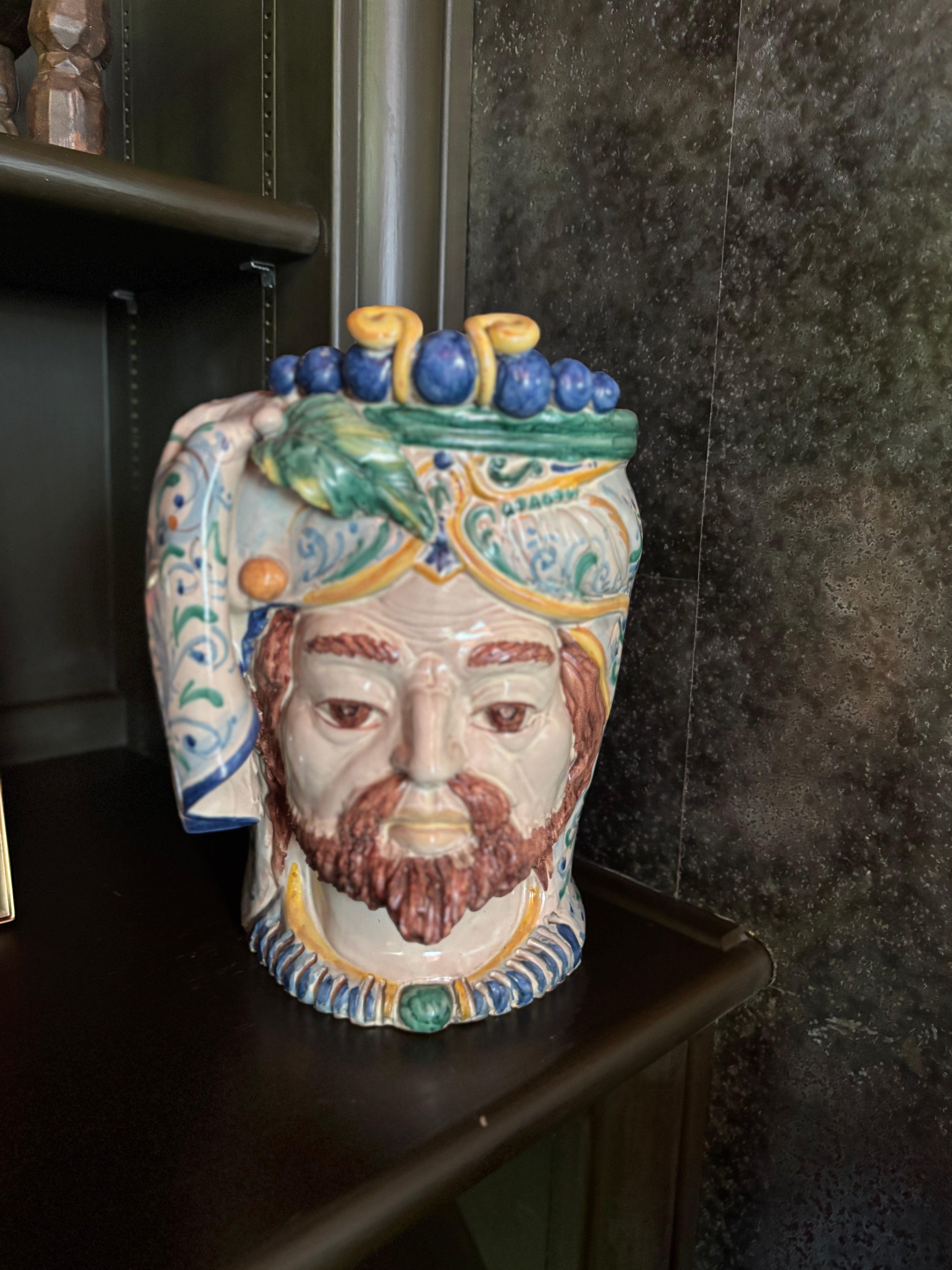 
In vendita: Scultura in terracotta con testa di re siciliano - dipinta a mano

Porta un pezzo di storia e di arte mediterranea nella tua casa con questa scultura in terracotta a forma di testa di re siciliano. Questo splendido pezzo artigianale è