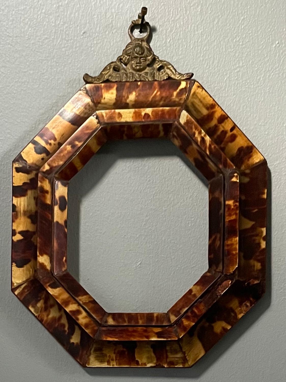 Sicilian tortoiseshell frame. Antique octagonal frame in beautiful condition smoothly applied with antique tortoiseshell and original brass hook; for favourite photo or small mirror. Italy, early 19th century. 
Dimensions: 12