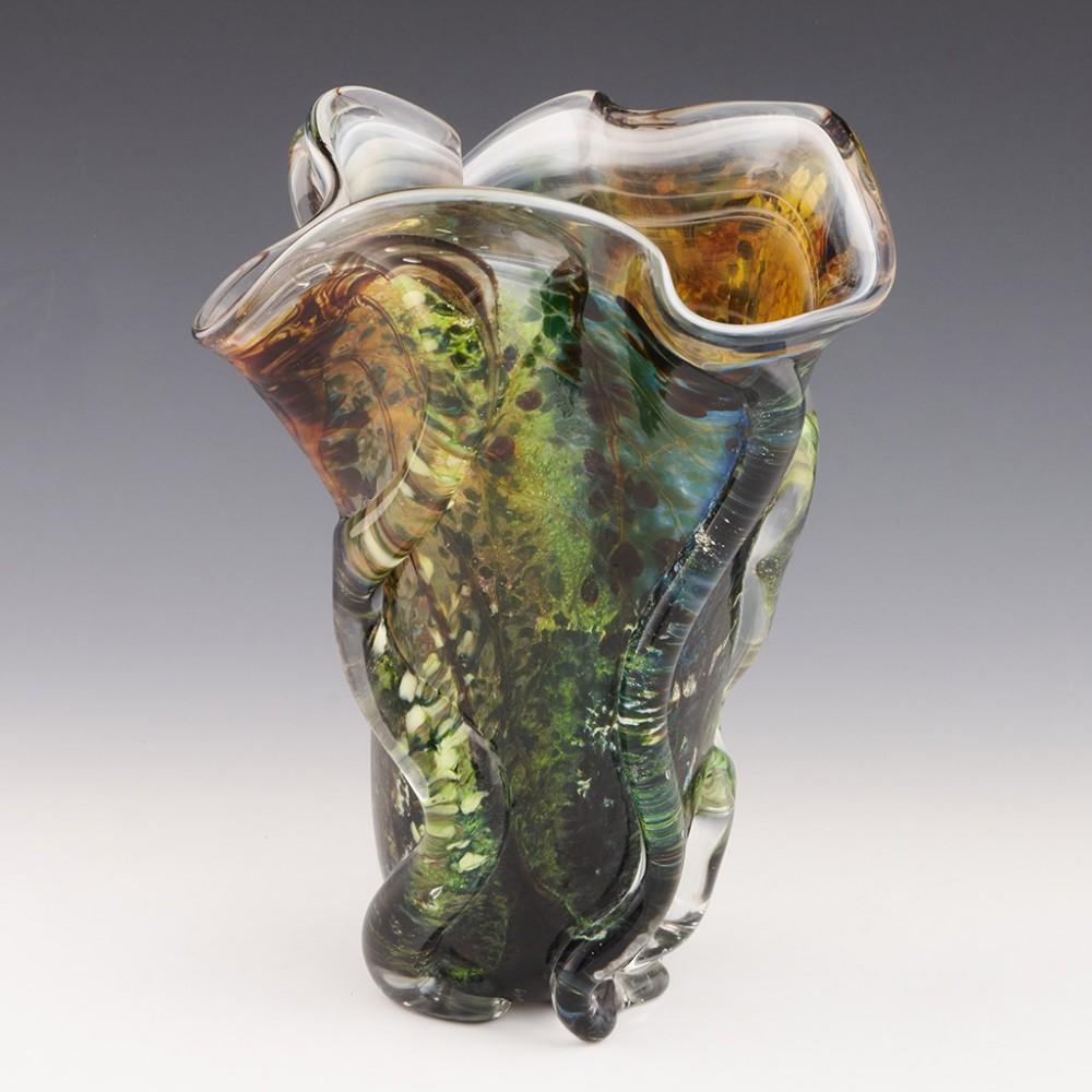 Heading : Siddy Langley freeform Rainforest vase
Date : 2021
Origin : Devon, England
Bowl Features : Polychrome glass cased in clear. Abstractly depicts a rainforest, the clear casing has distinct asymetircal curved ridges.
Marks : Signedc Siddy