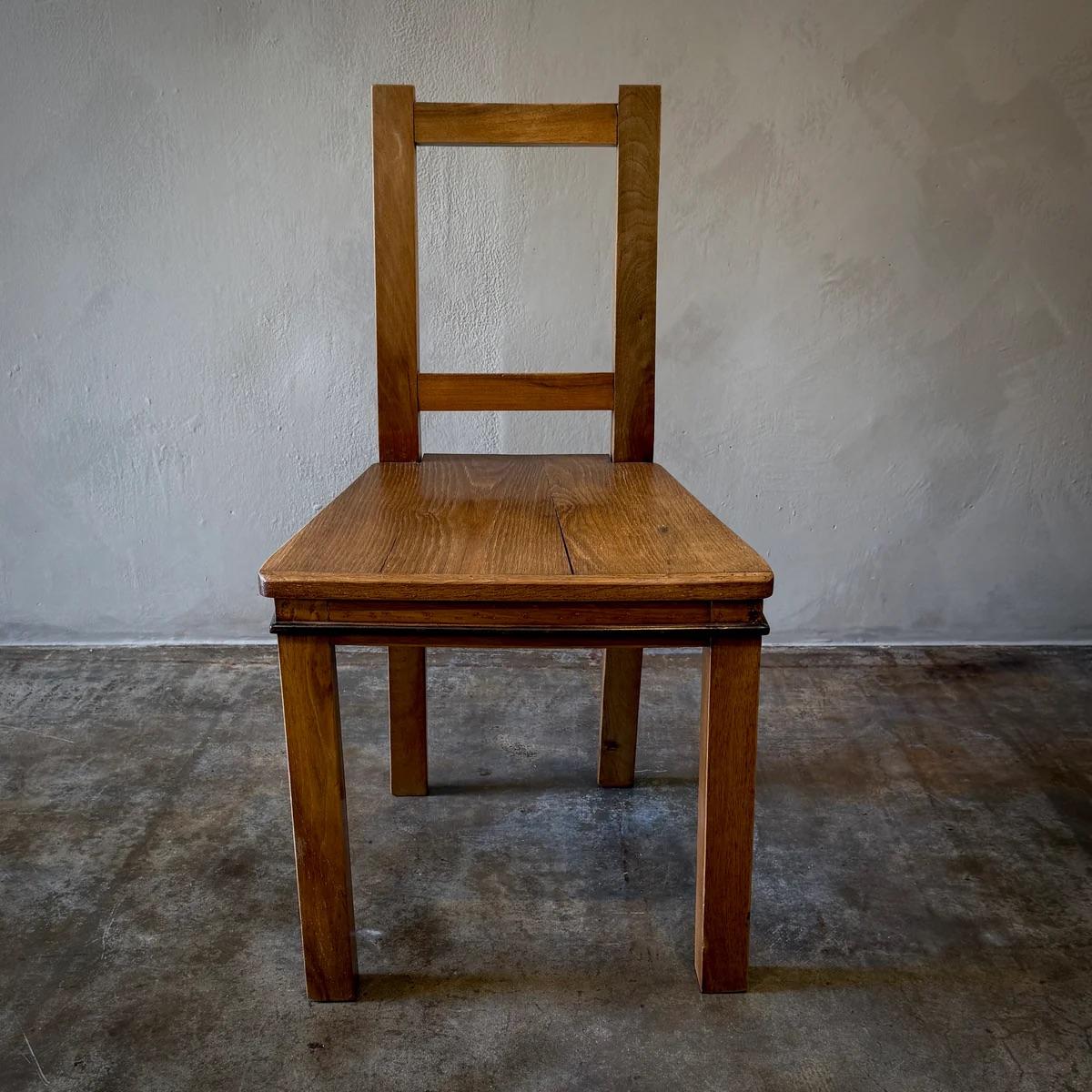 Cette chaise d'appoint illustre l'élégance du design minimaliste, alliant la chaleur du bois à la touche industrielle des détails en fer. Le design de la chaise se caractérise par un dossier mince et vertical qui s'élève avec une courbe gracieuse,