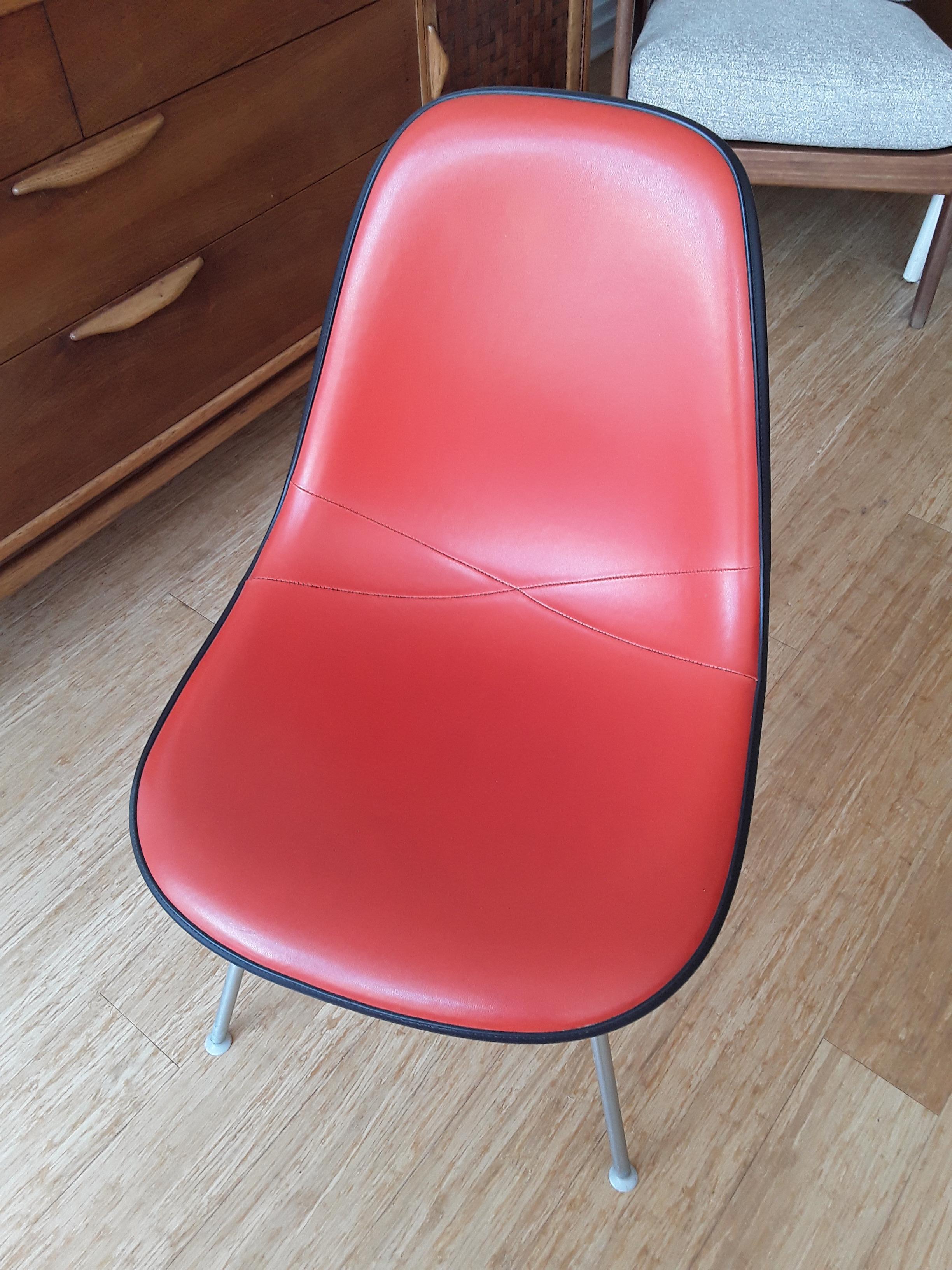 Eames fiberglass shell chair. Upholstered in orange Naugahyde.