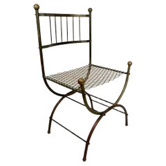 Silla auxiliar con armazón tubular de latón, asiento de malla metálica y remates de bola c 1930/40