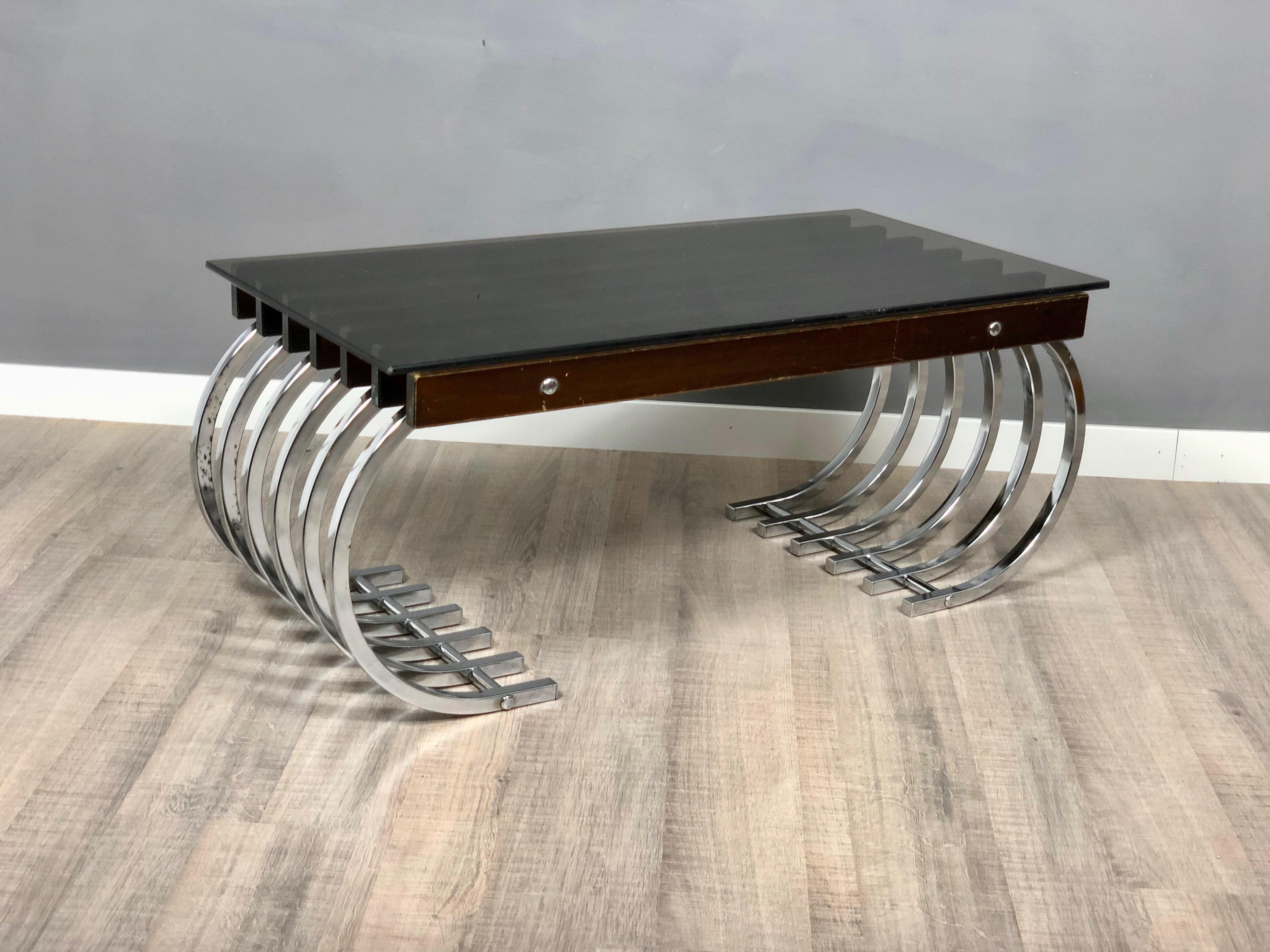 Amazing side or coffee table with curved chrome legs and the base of the table is made of wooden beams on which the smoked glass surface rests. The chrome and the wood have some sign of the time, as the photos show.