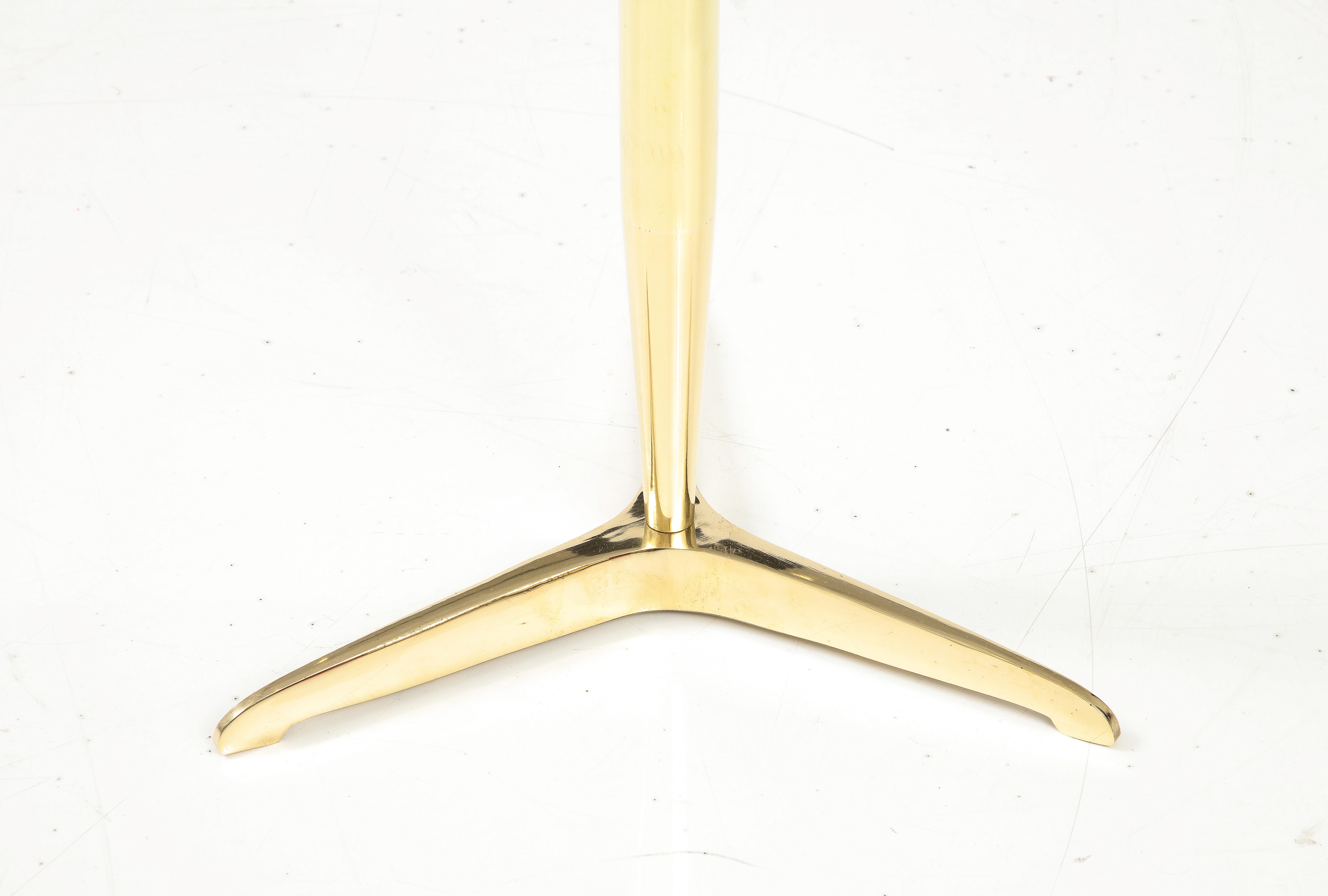Occasional Martini drinks side table with thick beveled glass and patinated brass tripod base and small brass handle detail.  Handmade in Italy, 2022. This bespoke modern side or martini table is handcrafted with thick lens cut polished beveled