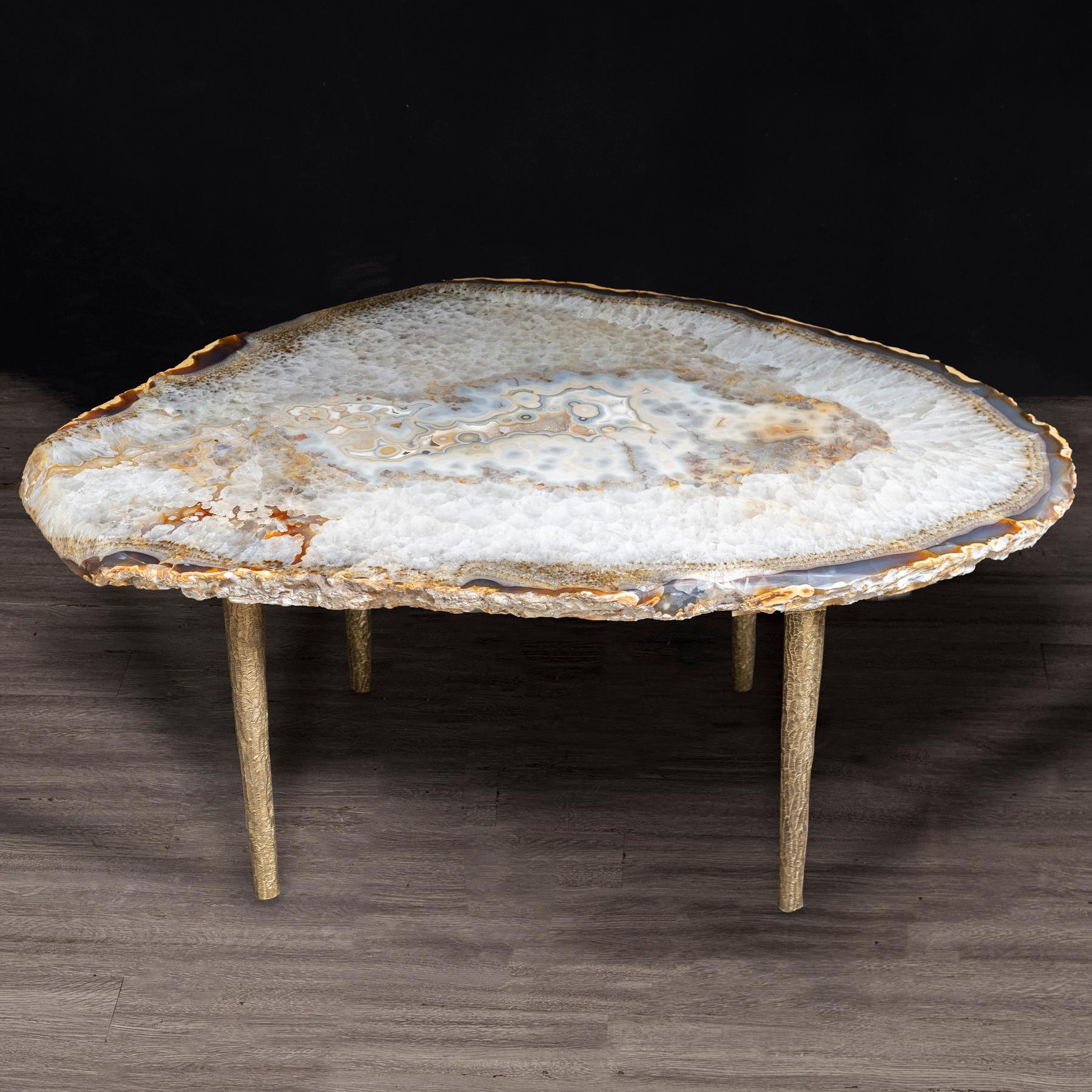 This agate slab forming a side table or cocktail table, is from Brazil and has a combination of colors with hints of blue and gold. Agates are formed in rounded nodules, which are sliced open to bring out the internal pattern hidden in the stone.
