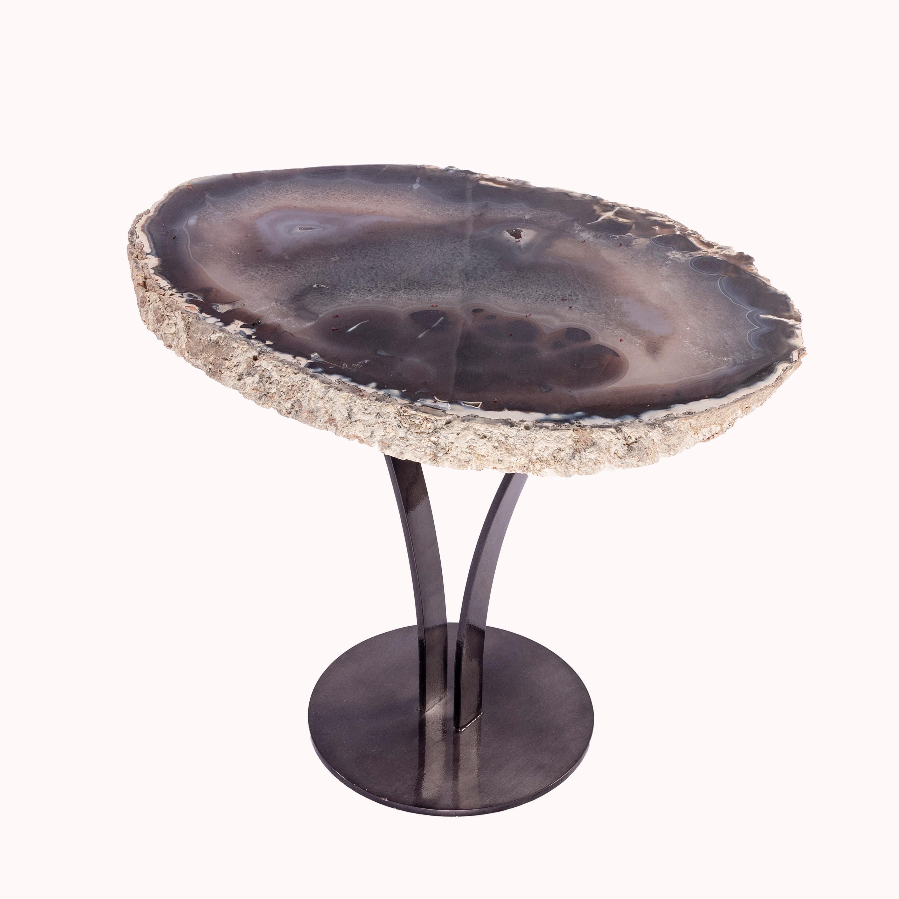 This agate slab forming a side table or cocktail table, is from Brazil and has a combination of colors with hints of blue, grey and white. Agates are formed in rounded nodules, which are sliced open to bring out the internal pattern hidden in the