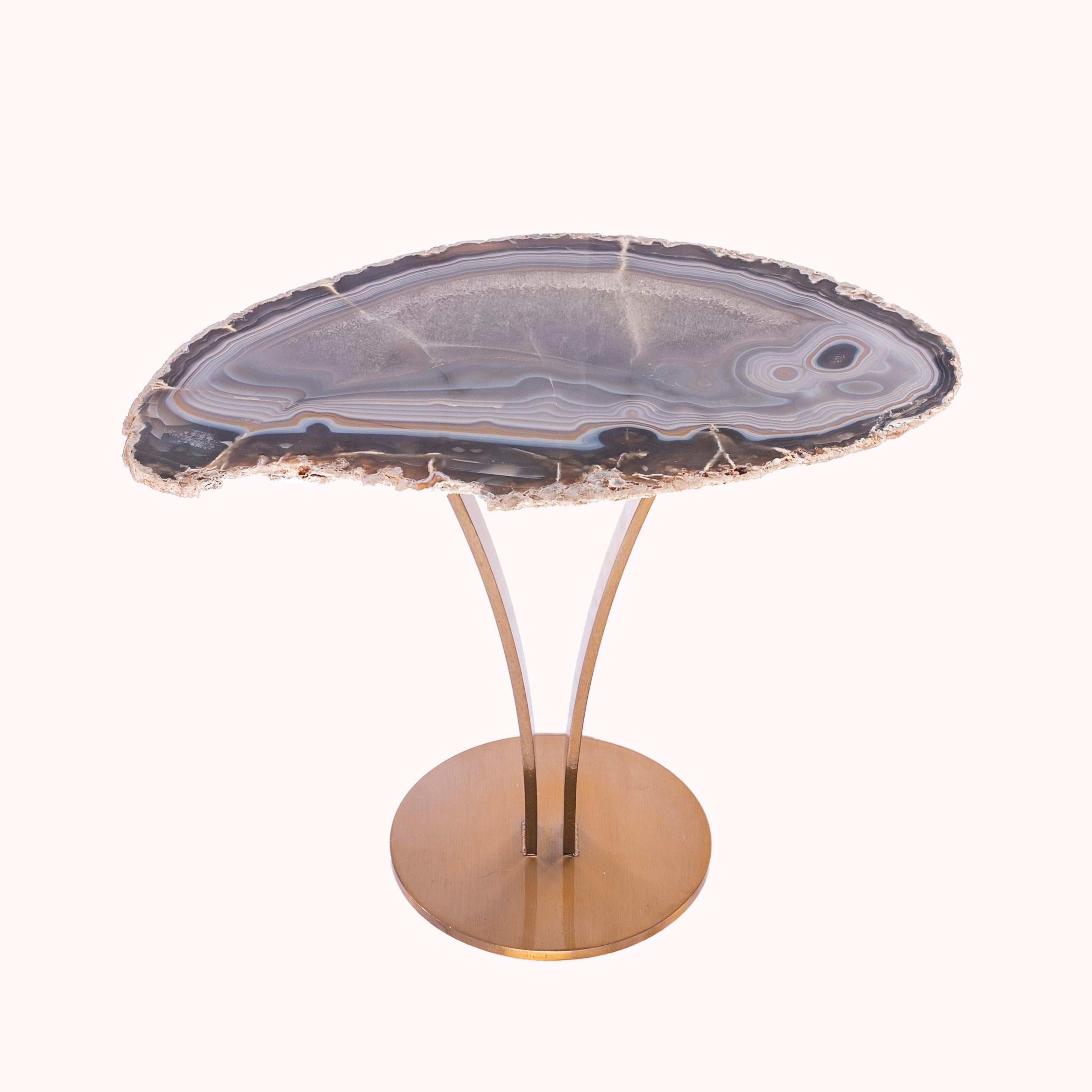 This agate slab forming a side table or cocktail table, is from Brazil and has a combination of colors with hints of blue, grey, brown and white. Agates are formed in rounded nodules, which are sliced open to bring out the internal pattern hidden in
