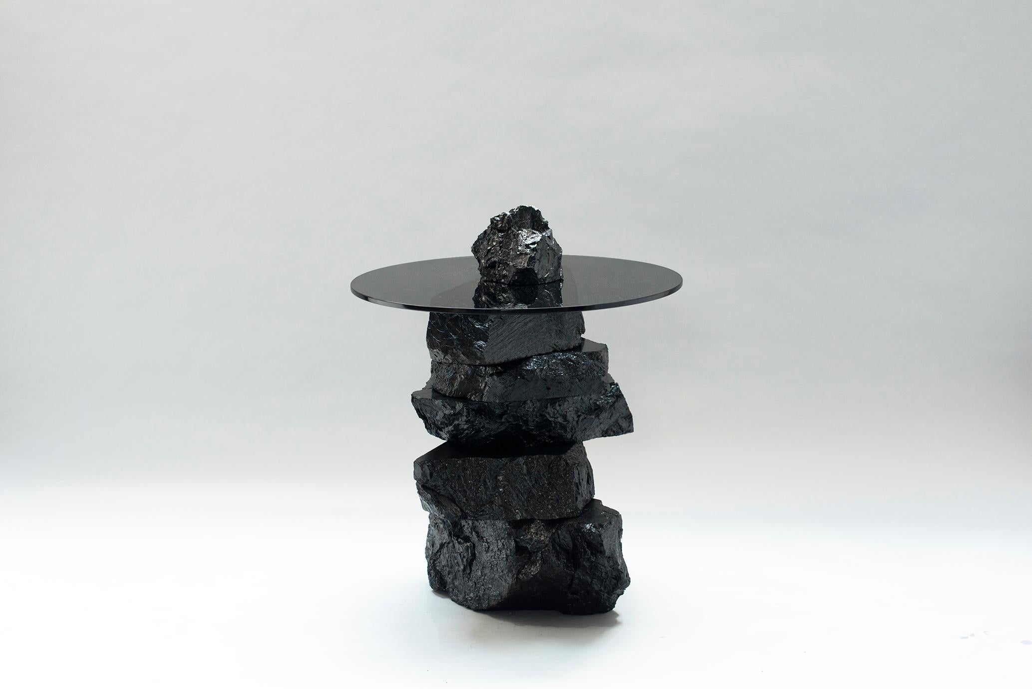 Table d'appoint 019 de Jesper Eriksson
Dimensions : D&H 60 x L 60 x H 70 cm 
Matériaux : charbon anthracite, verre trempé
Poids : 75 kg

Jesper Eriksson (né en 1990 à Paris) est un artiste et un designer basé à Londres, qui s'intéresse au travail