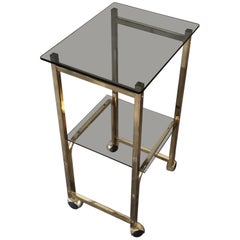 Mesa auxiliar años 70 cristal ahumado/oro/ruedas