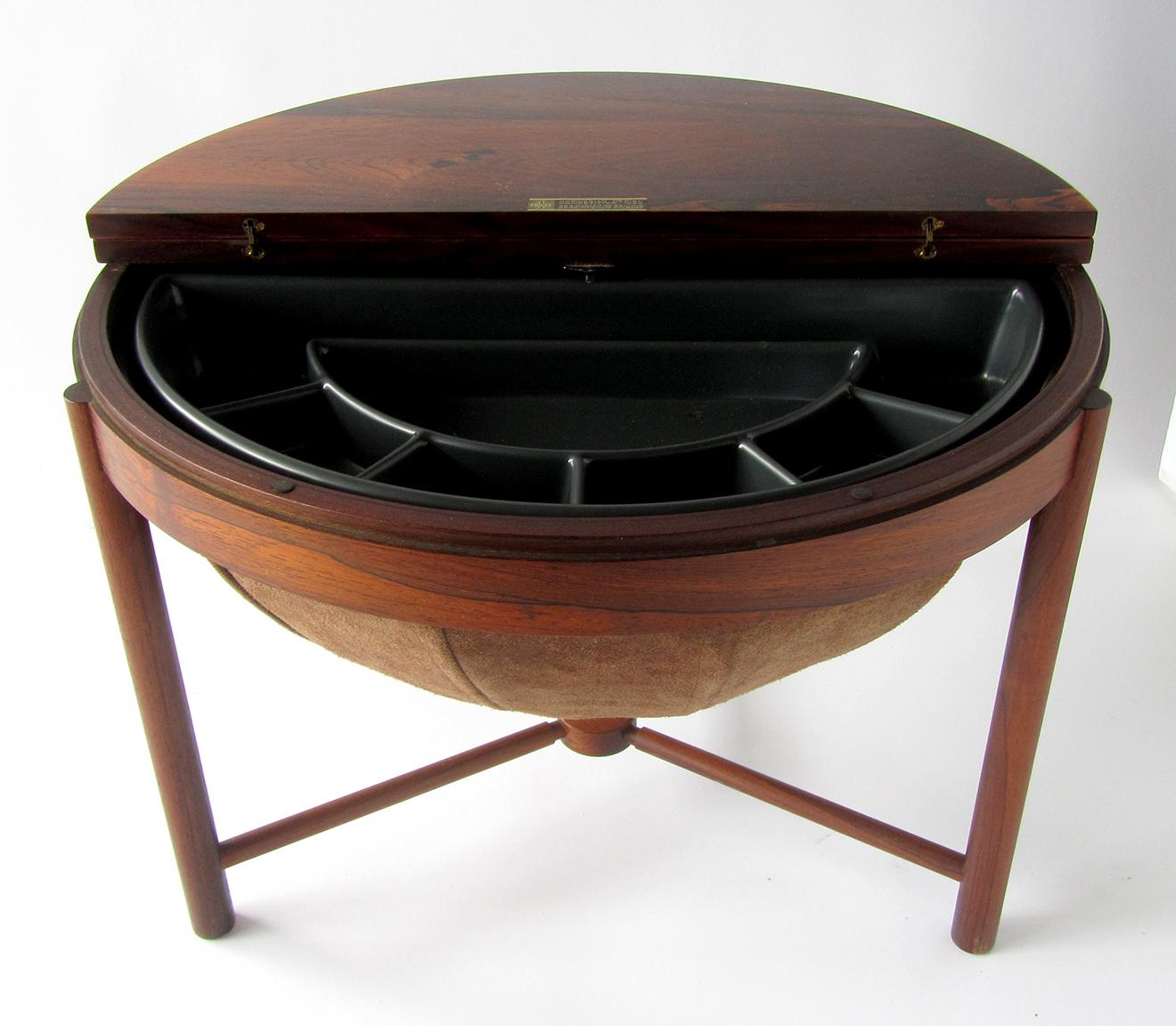 A handsome side table by Rastad & Relling for Rasmus Solberg. The Hinged top opens to reveal storage and a rotating 1/2 tray with partitioned sections. The exotic cocobolo wood is in incredible condition and the basket/storage underneath is