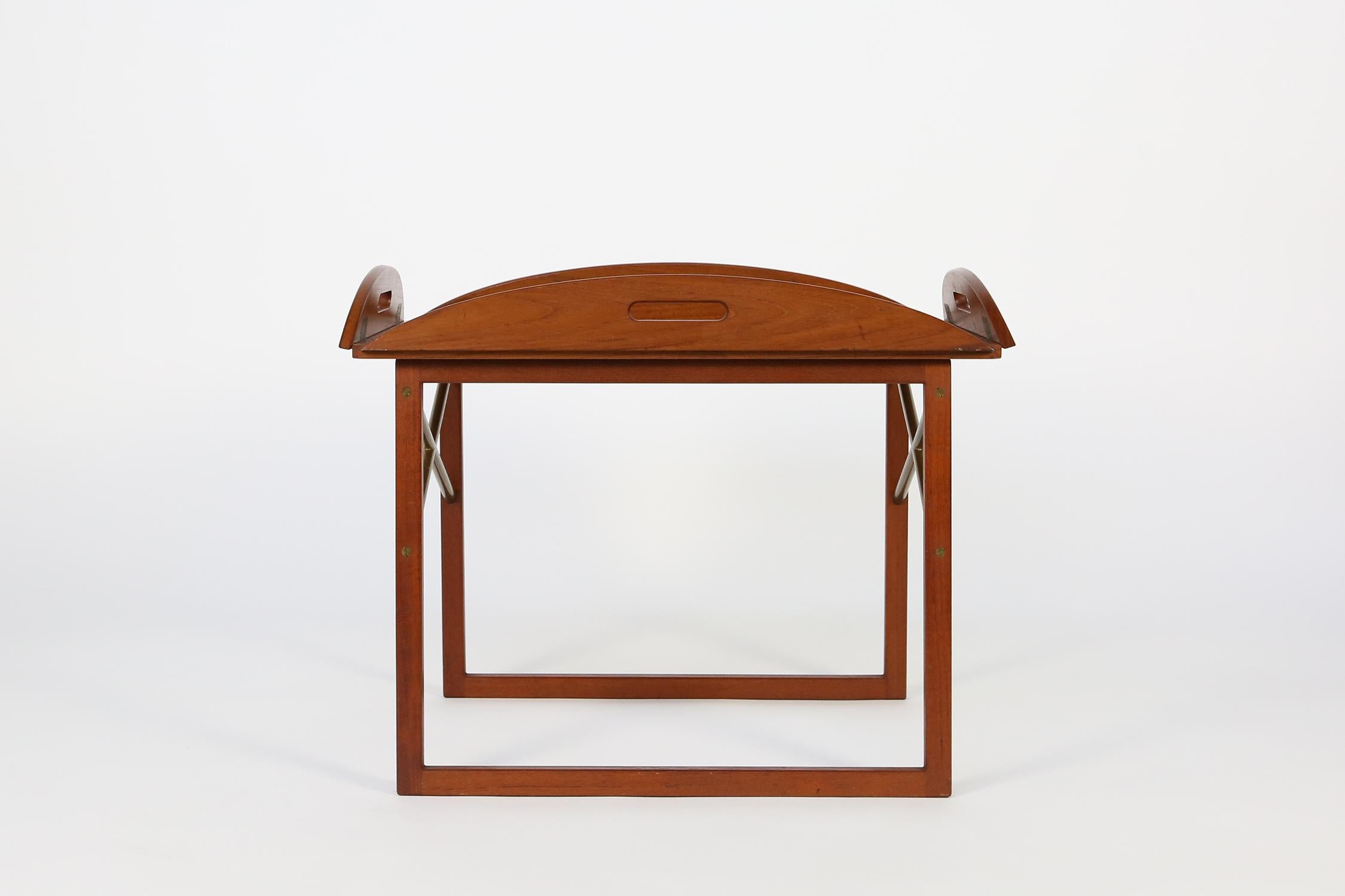 Teak side table with a removable rectangular top tray with hinged ends on an open frame base with brass cross stretchers.
Designed by Svend Langkilde for Illums Bolighus, circa 1960
Signed with metal manufacturer's label.