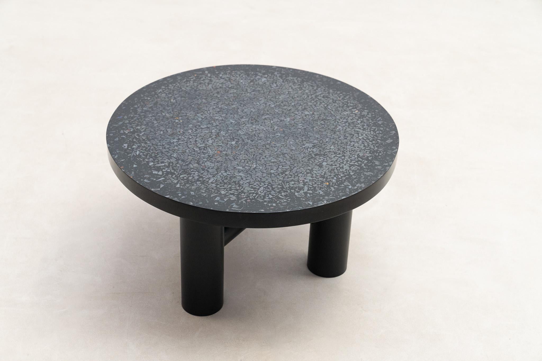 Esta mesa auxiliar del artista belga Etienne Allemeersch presenta un tablero circular meticulosamente incrustado con fragmentos de hematites, incrustados en resina lacada negra. Los tonos metálicos naturales de la hematites añaden un contraste sutil