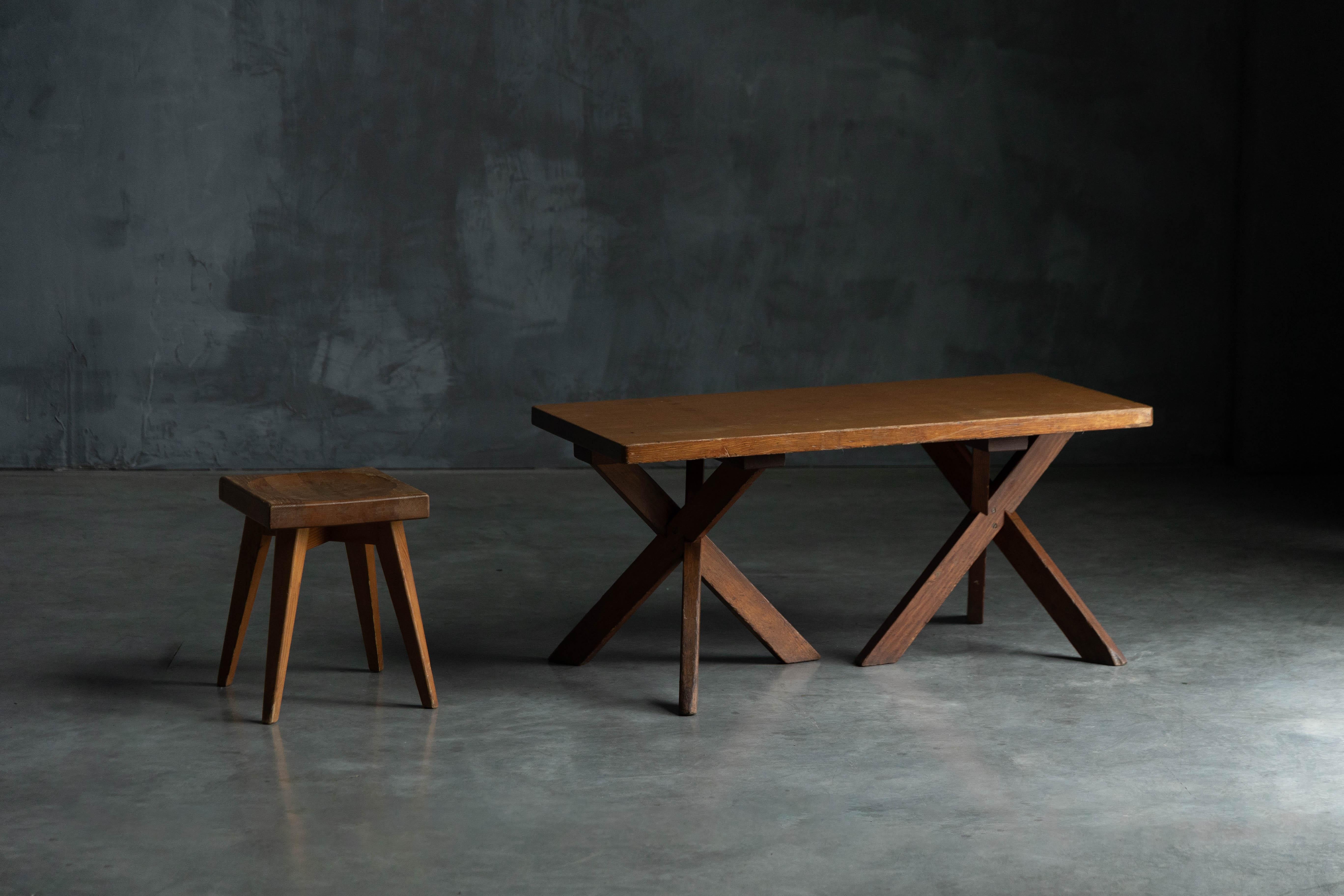 Cette table d'appoint, conçue par Charlotte Perriand pour l'Hôtel Les Trois Arcs en 1967-1968, est une pièce exceptionnellement rare, trois exemplaires seulement ayant été produits. Son piètement en trois parties en bois massif allie une stabilité