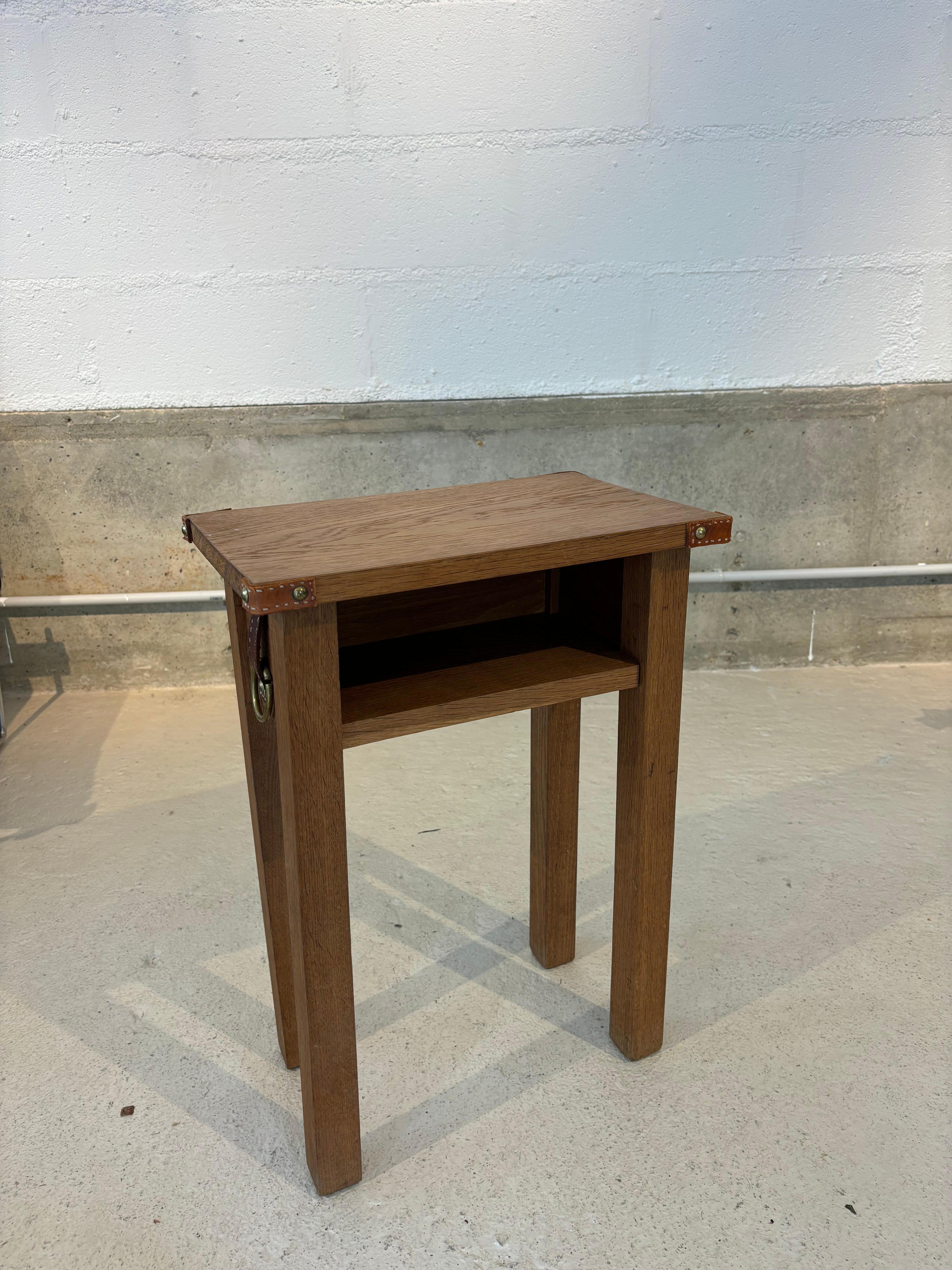 Jolie table d’appoint ou table de chevet par Jacques Adnet en cuir piqué cellier et chêne.  