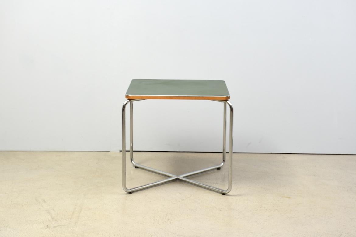 Well preserved side table by Marcel Breuer for Bigla, Switzerland. 1930s. With characteristic crossed tubular steel table legs. Green linoleum surface with age-related signs of wear.