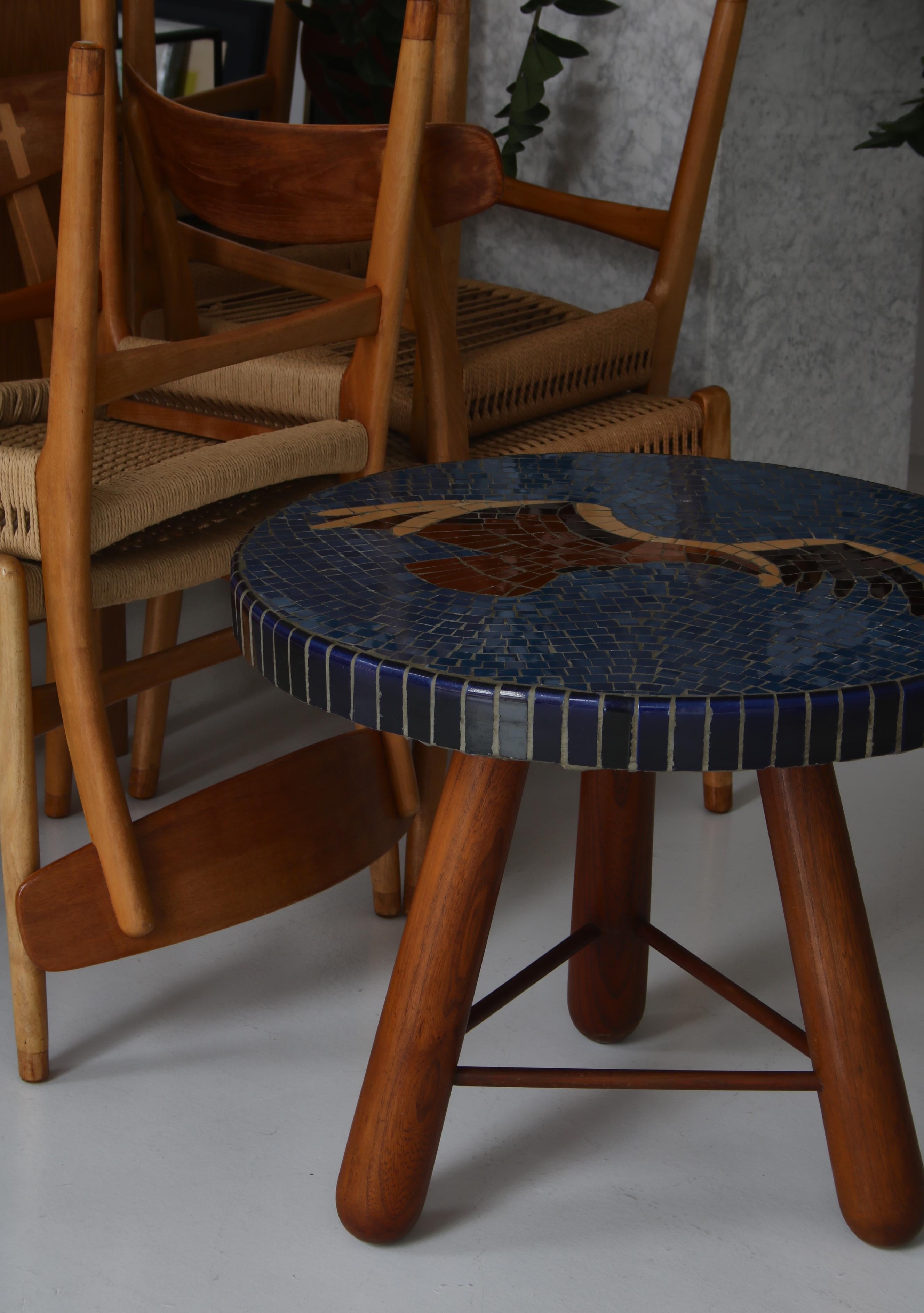 Amazing modernist side or coffee table made by Danish cabinetmaker Otto Færge in the 1940s. The oval table top is decorated by the artist Paul Hedegård with a mosaic depicting an eagle on a deep blue background of ceramic tiles. The big chunky club
