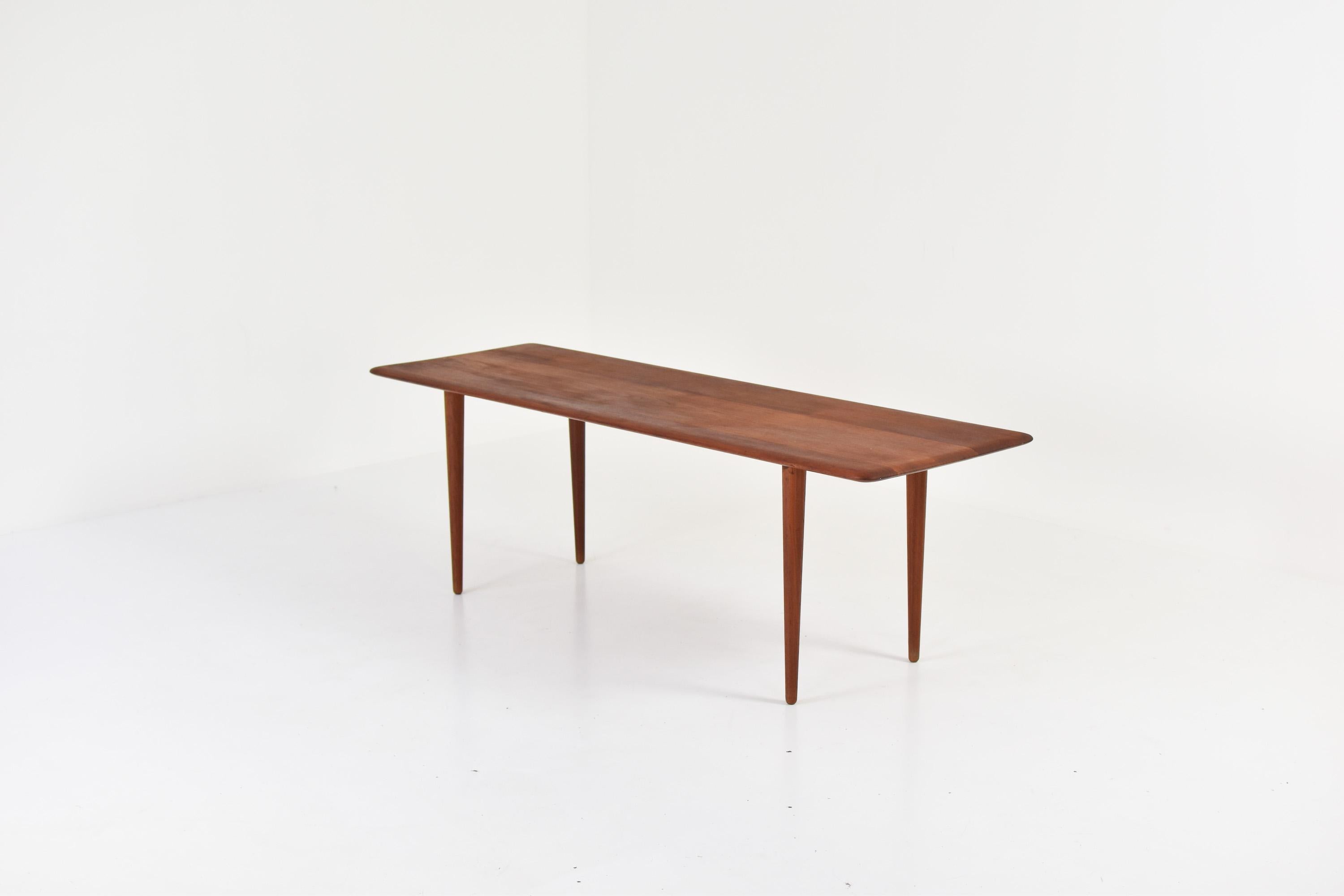 Side table in teak by Peter Hvidt & Orla Molgaard-Nielsen for France & Son, Denmark, 1960s. This piece features a solid teak top with curved edges and nice tall thin legs. Very good condition. Labeled underneath.