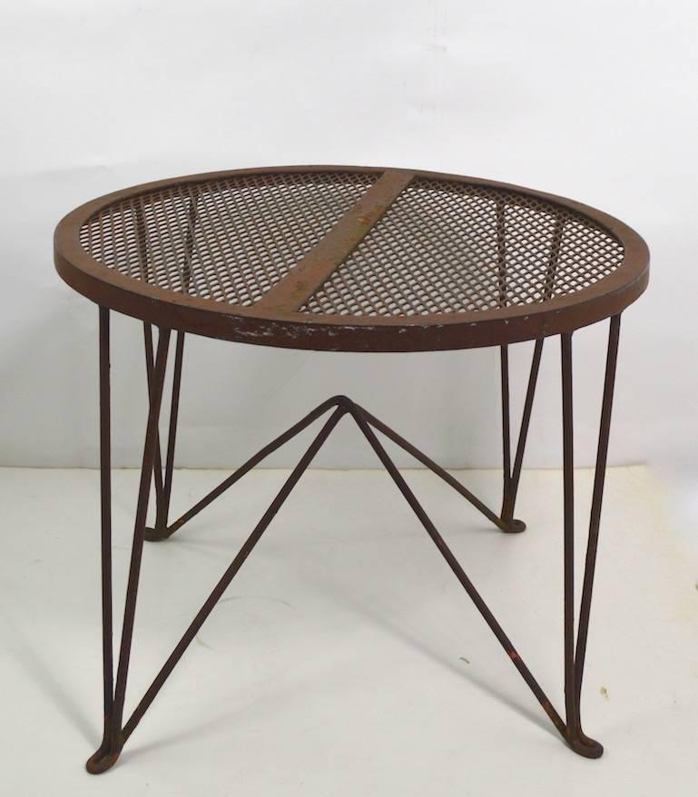 Architectural side table manufactured by Salterini, design attributed to Tempestini.
Metal mesh top with wrought iron rod base, currently in original brown paint finish (shows wear). We offer custom powder coating if you prefer a more polished