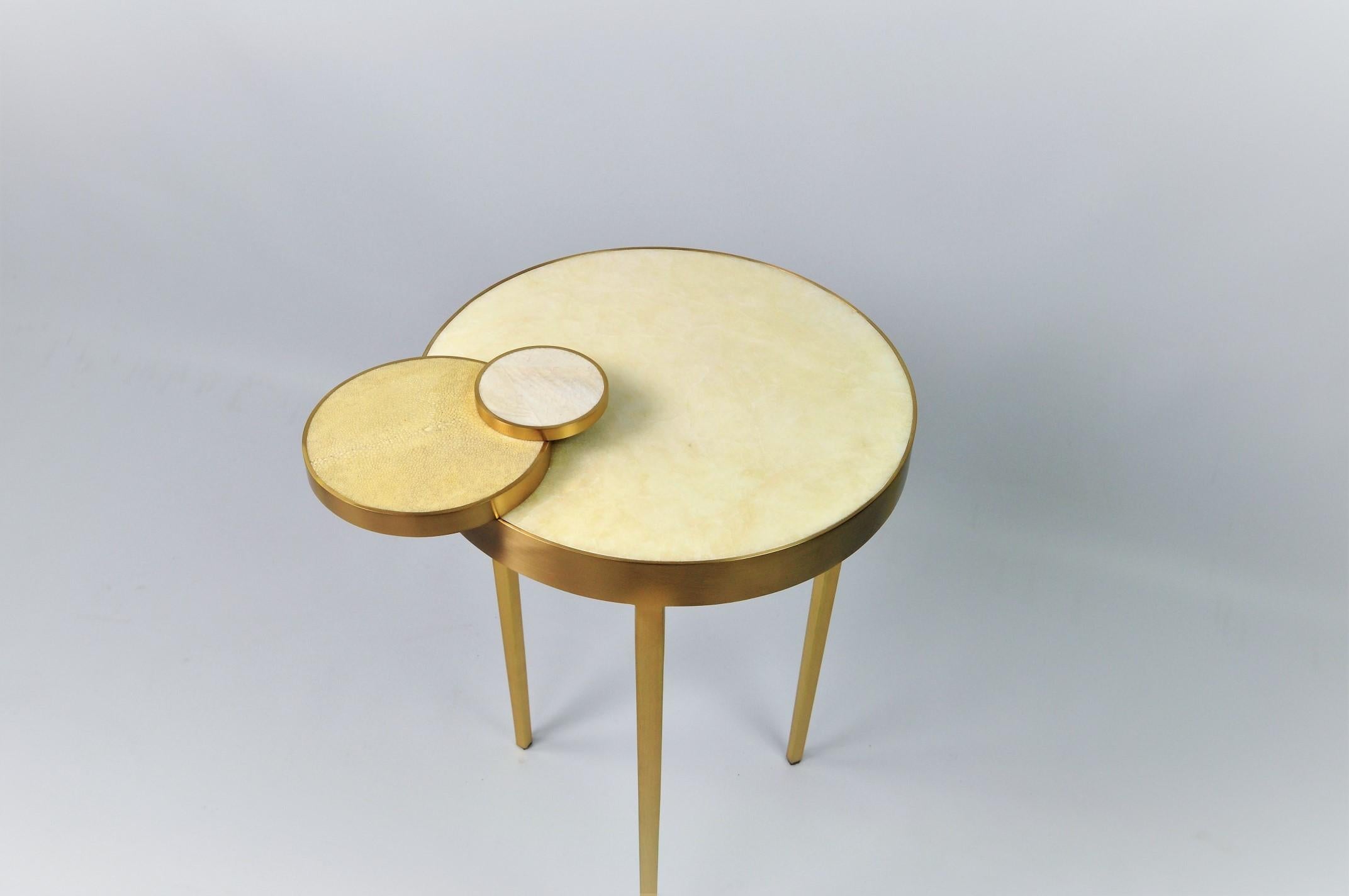 The CIRCULO side table by GINGER BROWN is made of brass with a round top in rock crystal marquetry.
The brass has been brushed to give a modern finish aspect.
The round decors have different finishes. While the larger one is in shagreen, the
