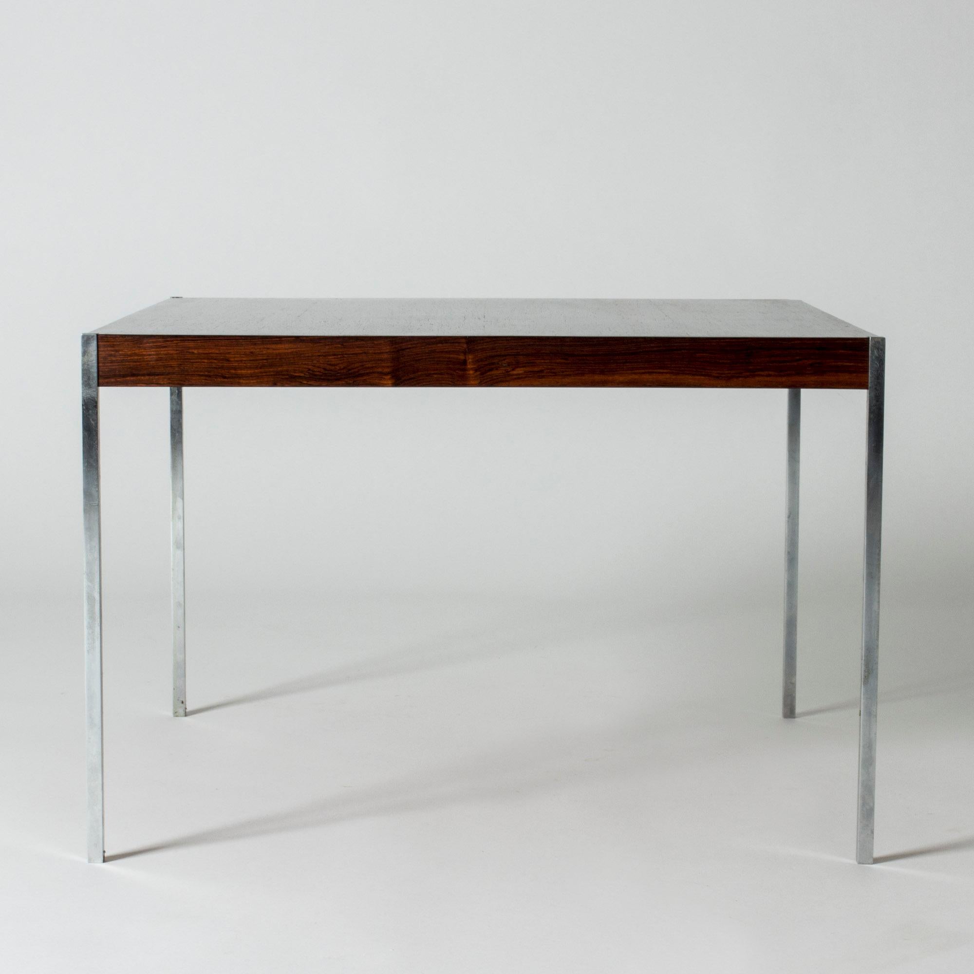 Neat rosewood side or small coffee table by Uno and Östen Kristiansson. Sleek, clean lines, with slender steel legs. The top squares of the legs make cool details at the corners of the tabletop.