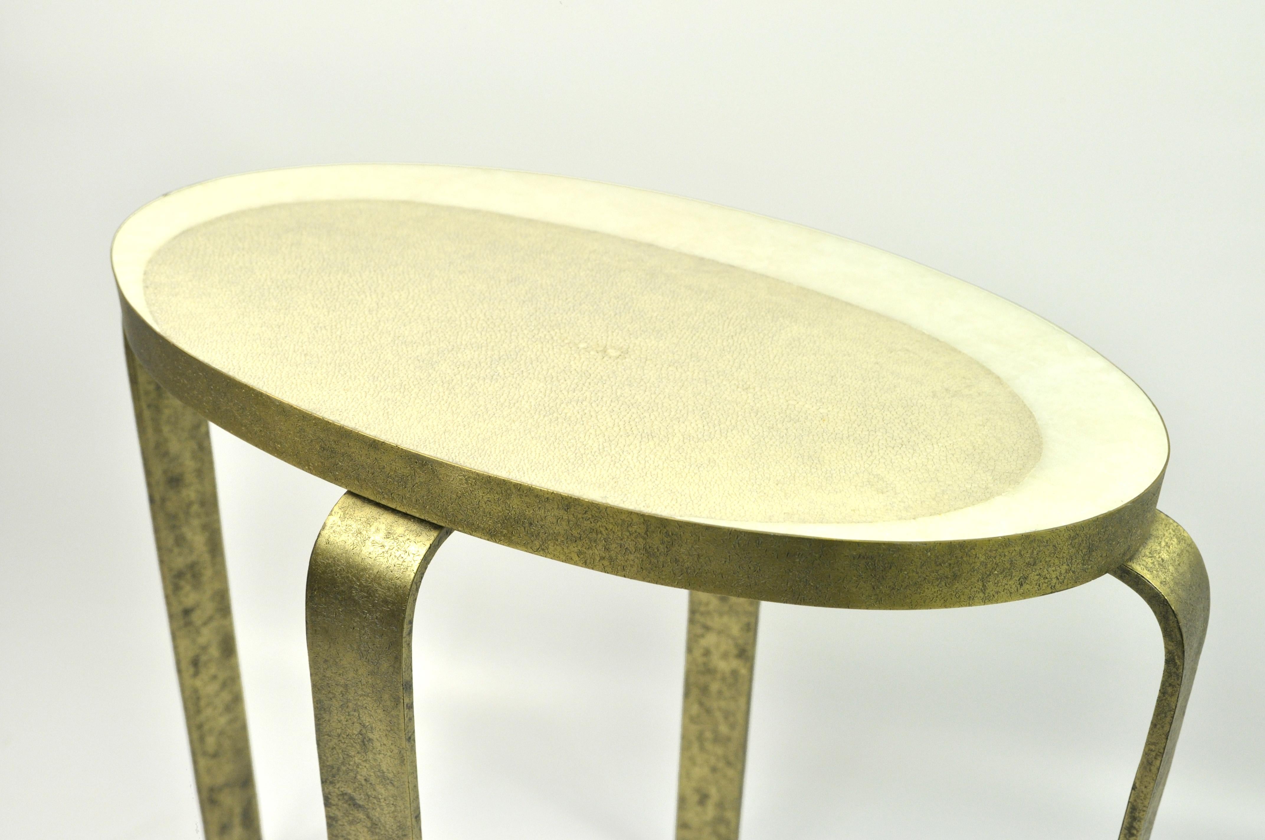 The Eliptus side table is made of textured brass with an oval shape genuine shagreen and rock crystal marquetry top.
The brass has been hammered by hand to give an irregular and artistic finish aspect.
The natural color of the shagreen contrasts