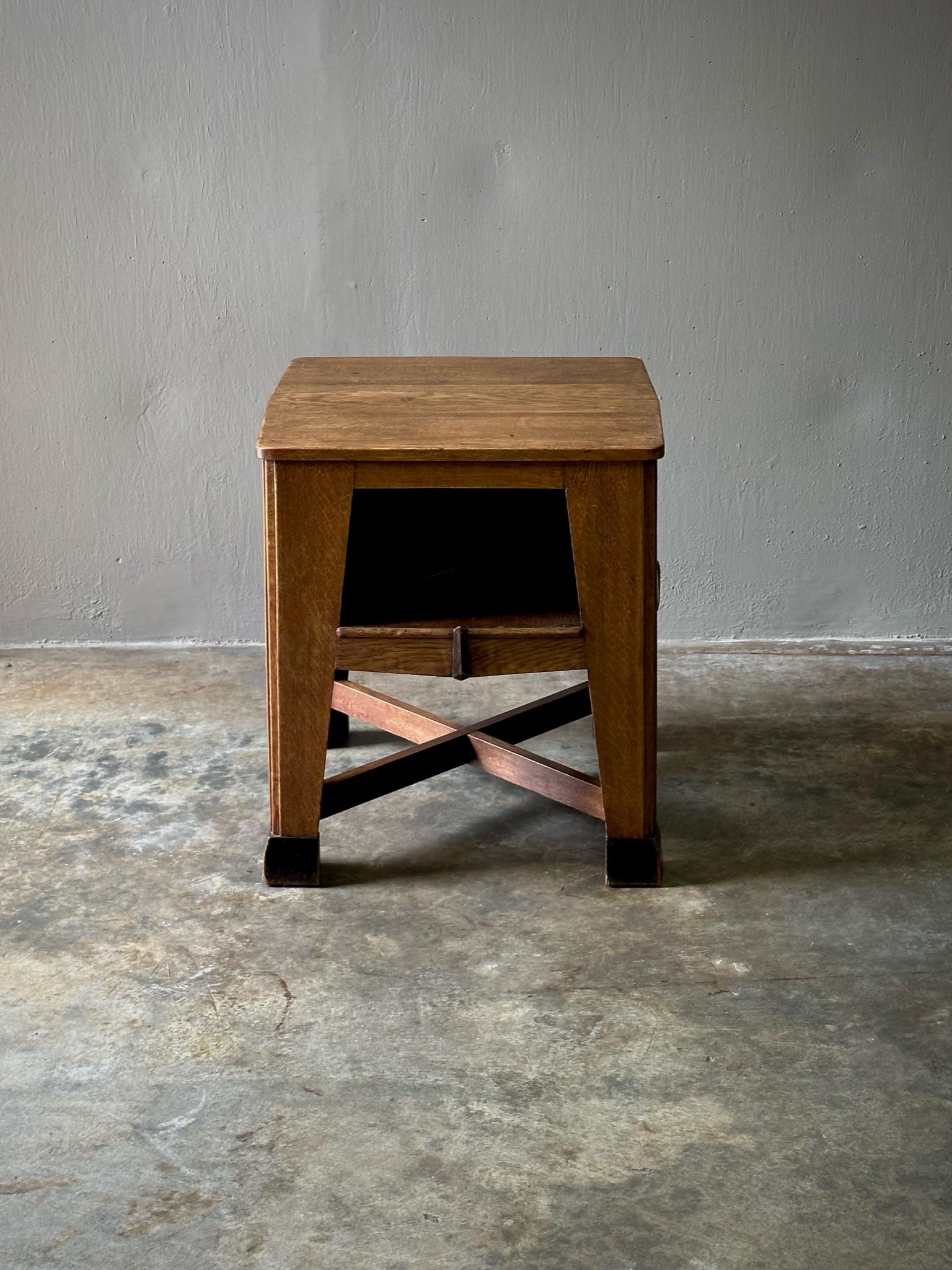 Dutch wood side table with square surface top, lower shelving units, and triangulated legs in the Amsterdam School style. The Amsterdamse School was known for its progressive, Bauhaus-adjacent ideology and combined elements of Art Nouveau and Art