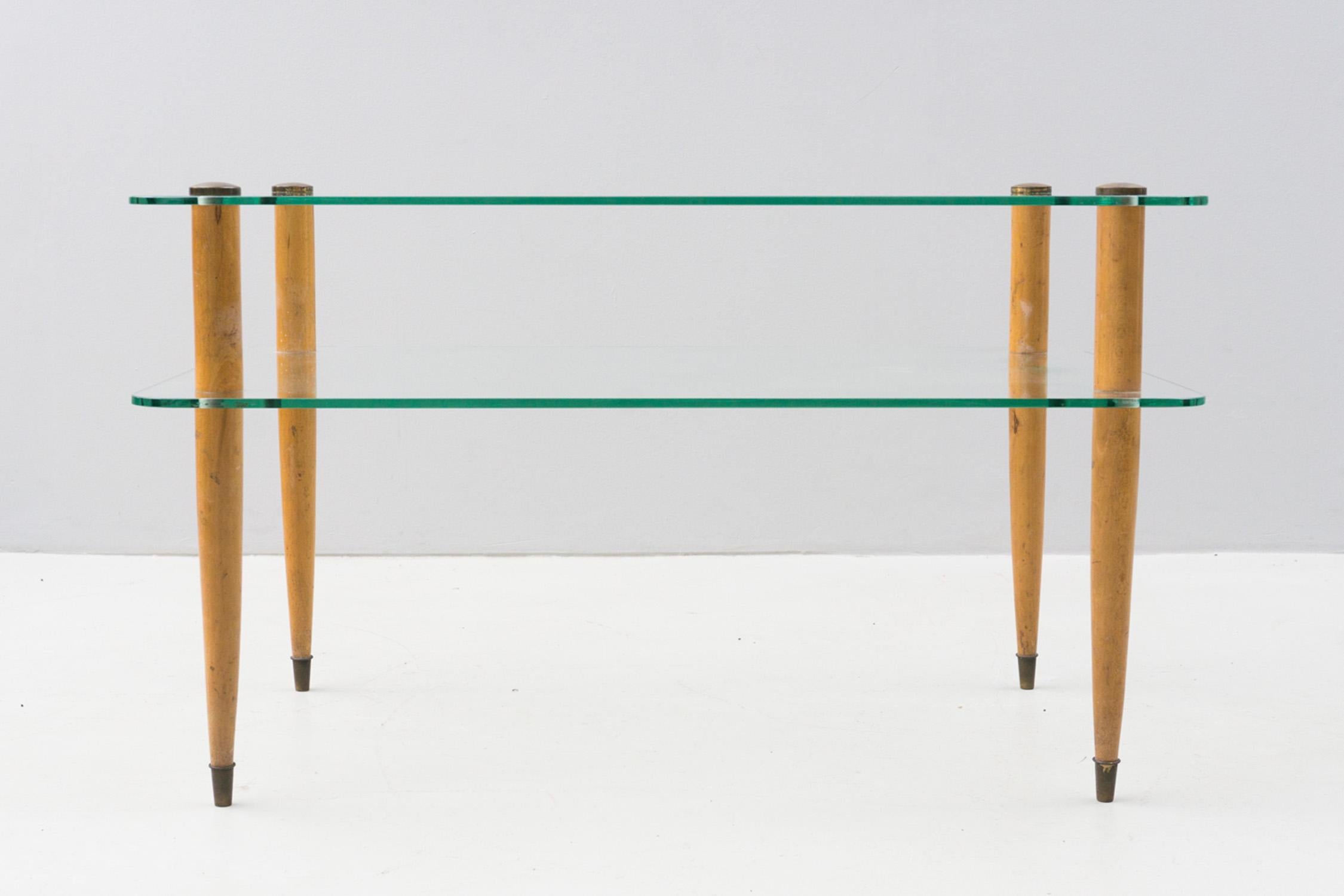 This elegant and minimal side table by Enrico Paolucci is made of two glass plates in original condition and solid wooden legs with brass applications. 

Enrico Paulucci (Genova, 13.10.1901 – Torino, 22.08.1999) was an Italian painter and part of