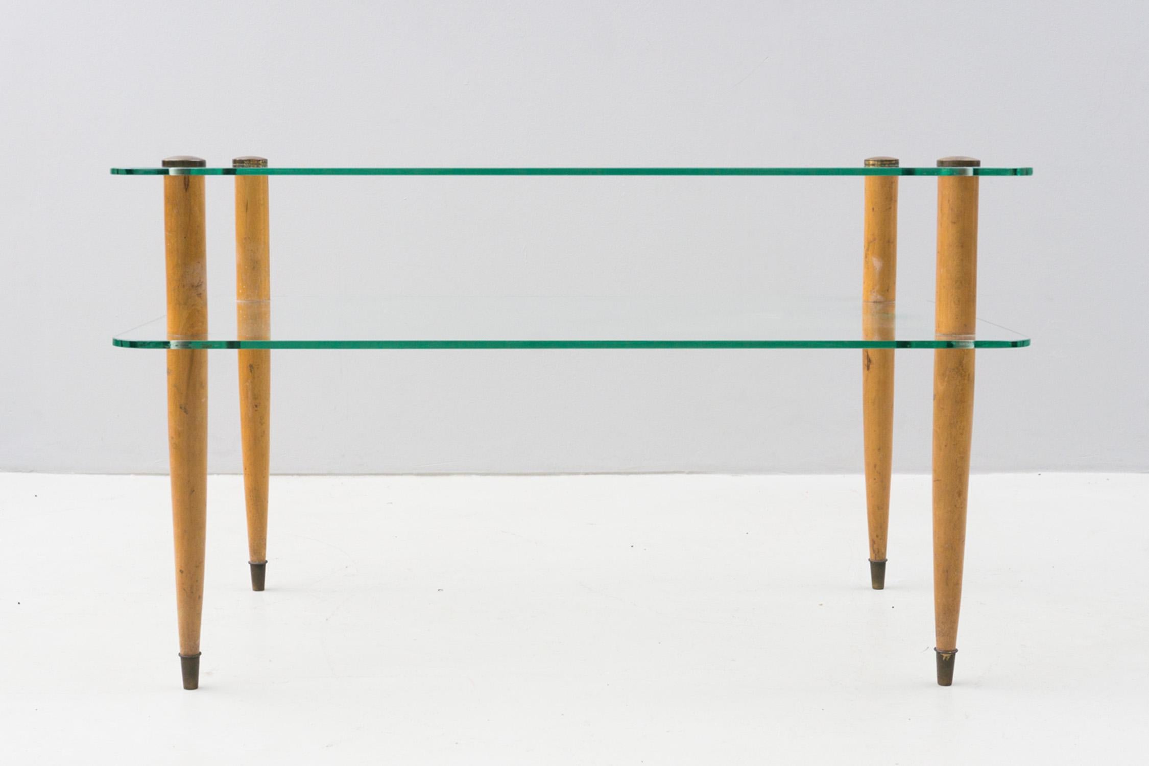 Cette table d'appoint élégante et minimale d'Enrico Paolucci est composée de deux plaques de verre en état d'origine et de pieds en bois massif avec applications en laiton. 

Enrico Paulucci (Gênes, 13.10.1901 - Turin, 22.08.1999) était un peintre