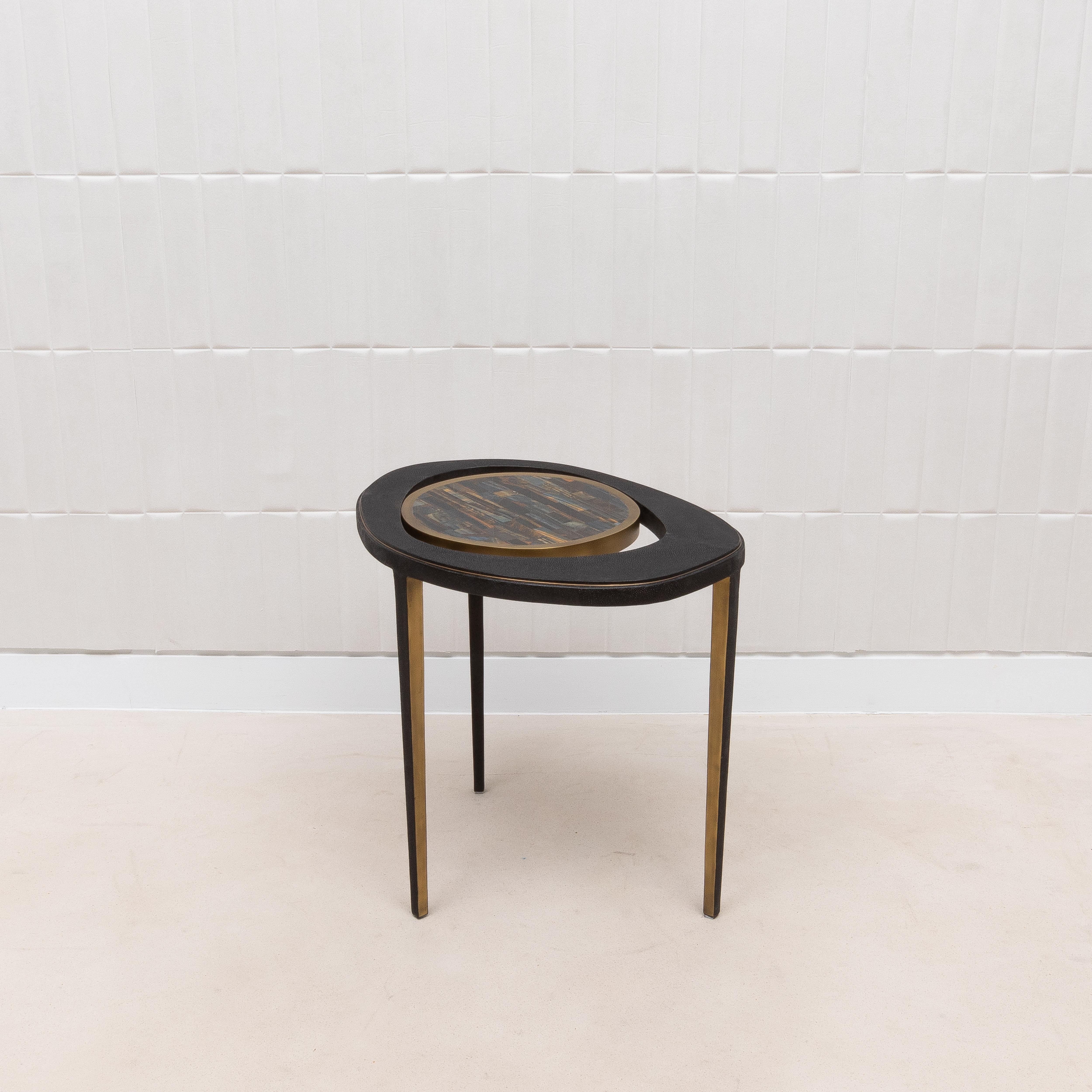 The Peacock Side Table by R&Y Augousti is a stunning example of luxurious design, where natural beauty meets modern elegance. The table's top, crafted from the mesmerizing Tiger Eye stone, exudes a rich, iridescent quality that is both captivating