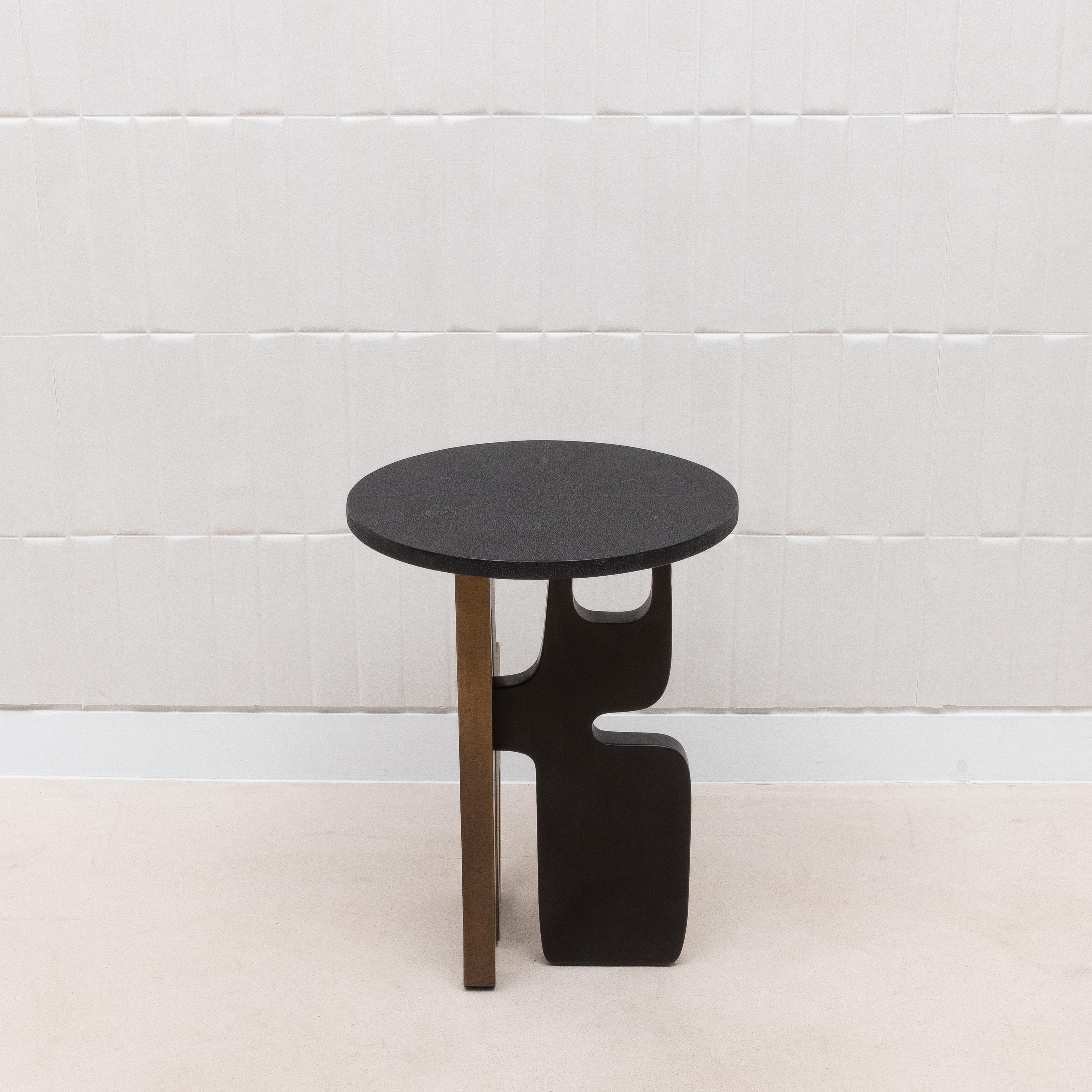 Der Beistelltisch Apoli von Kifu Paris besticht durch seine Kombination aus modernem Design und luxuriösen Materialien. Die aus tiefschwarzem Chagrin gefertigte Platte bietet eine glatte, raffinierte Oberfläche, die einen schönen Kontrast zu dem