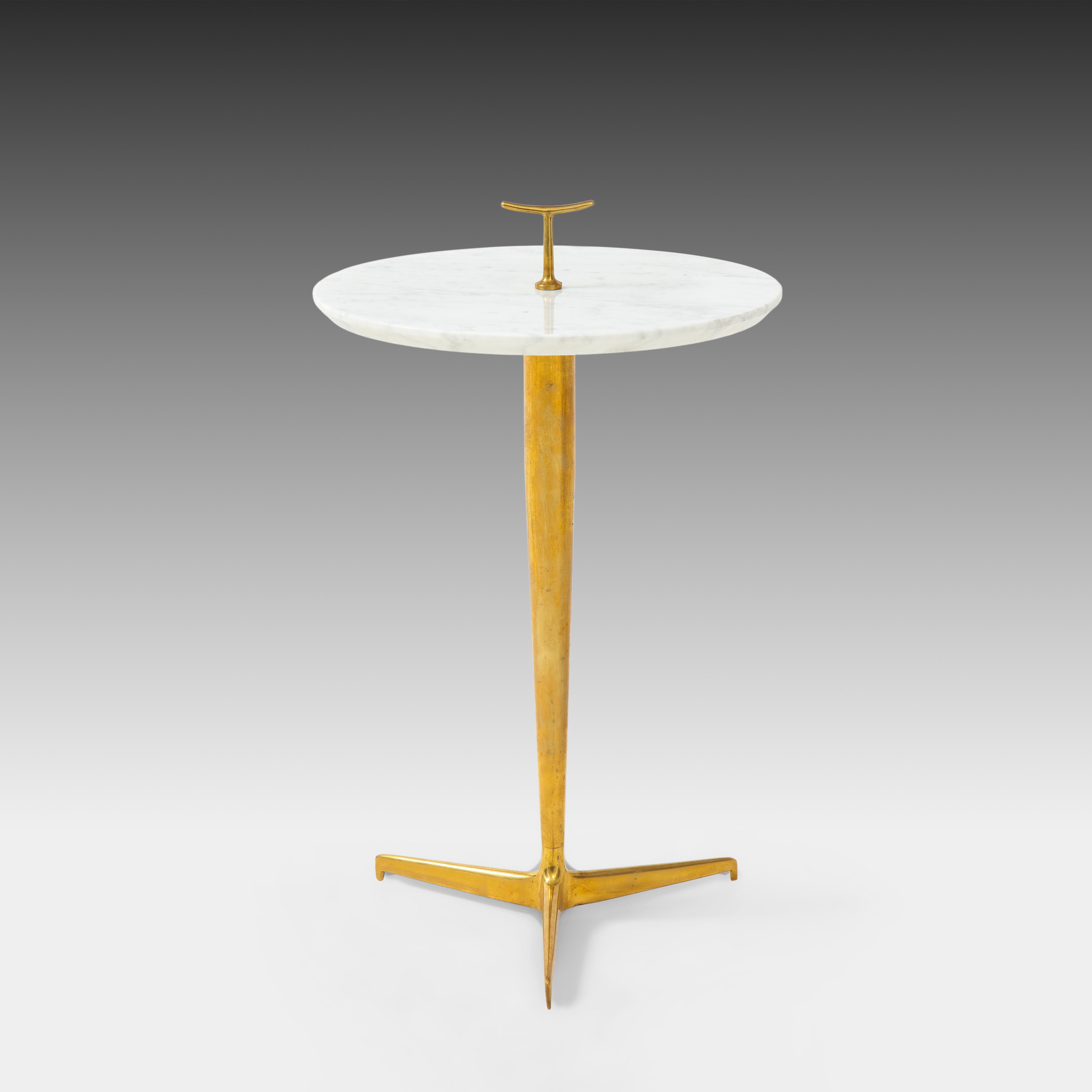 Contemporary side or drinks table in thick Carrara marble with small brass handle detail on patinated brass tripod base, Italy, 2022. This chic modern side table is beautifully constructed with thick reverse rounded Carrara marble top and richly